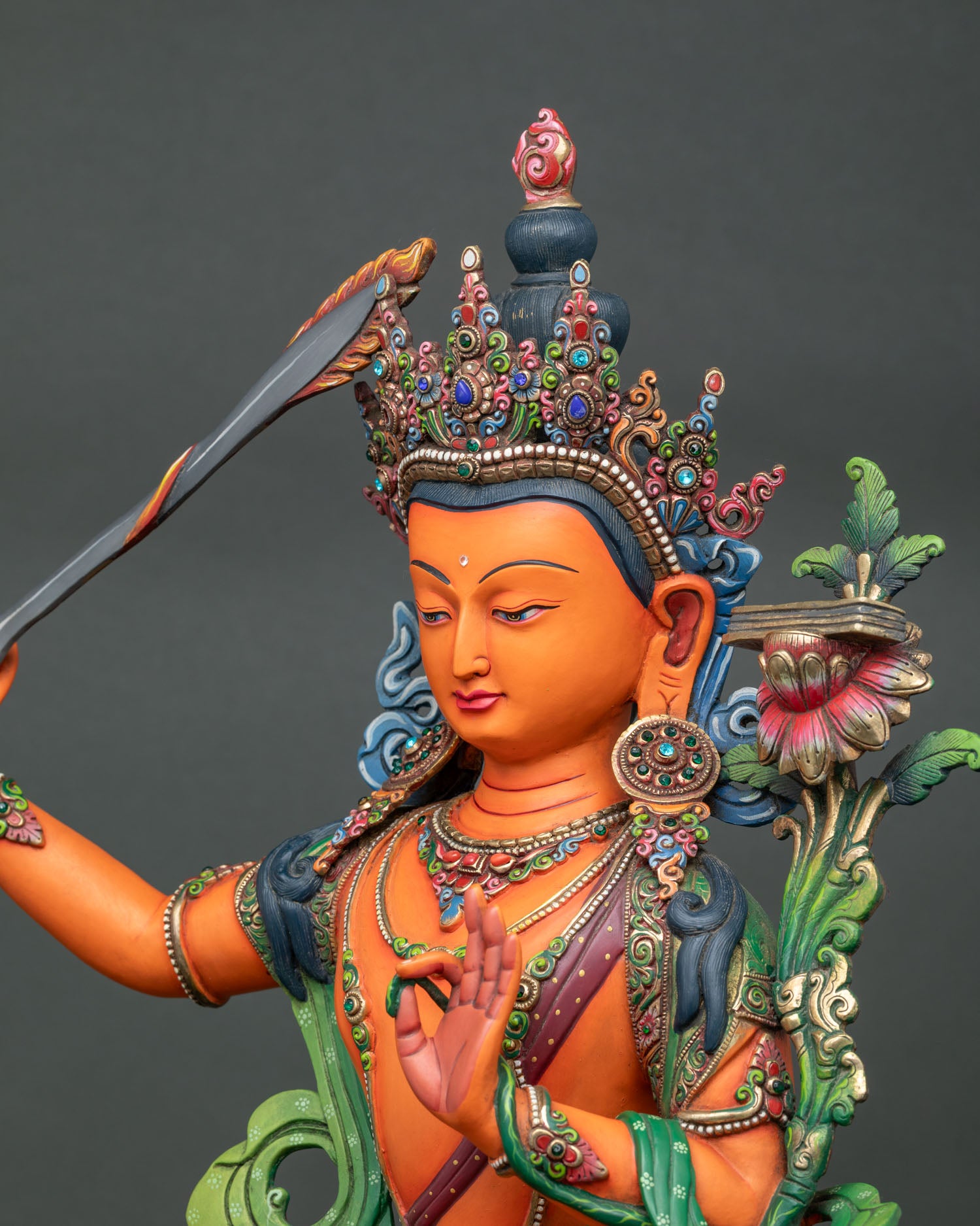 Detailed side close up of Manjushri statue with intricate crown and jewelry