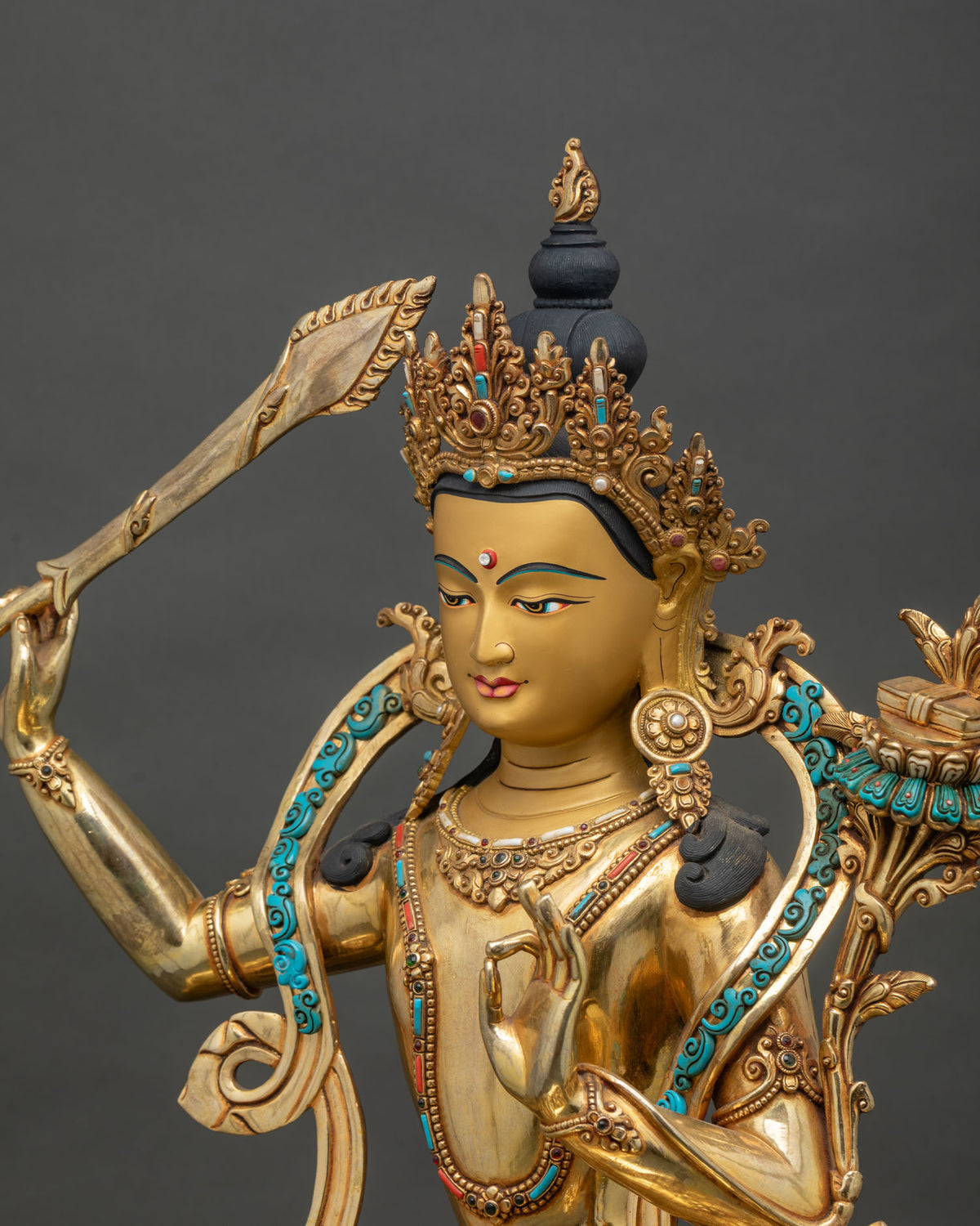 Detailed side close up of Manjushri statue with wisdom flame sword and turquoise coral inlays