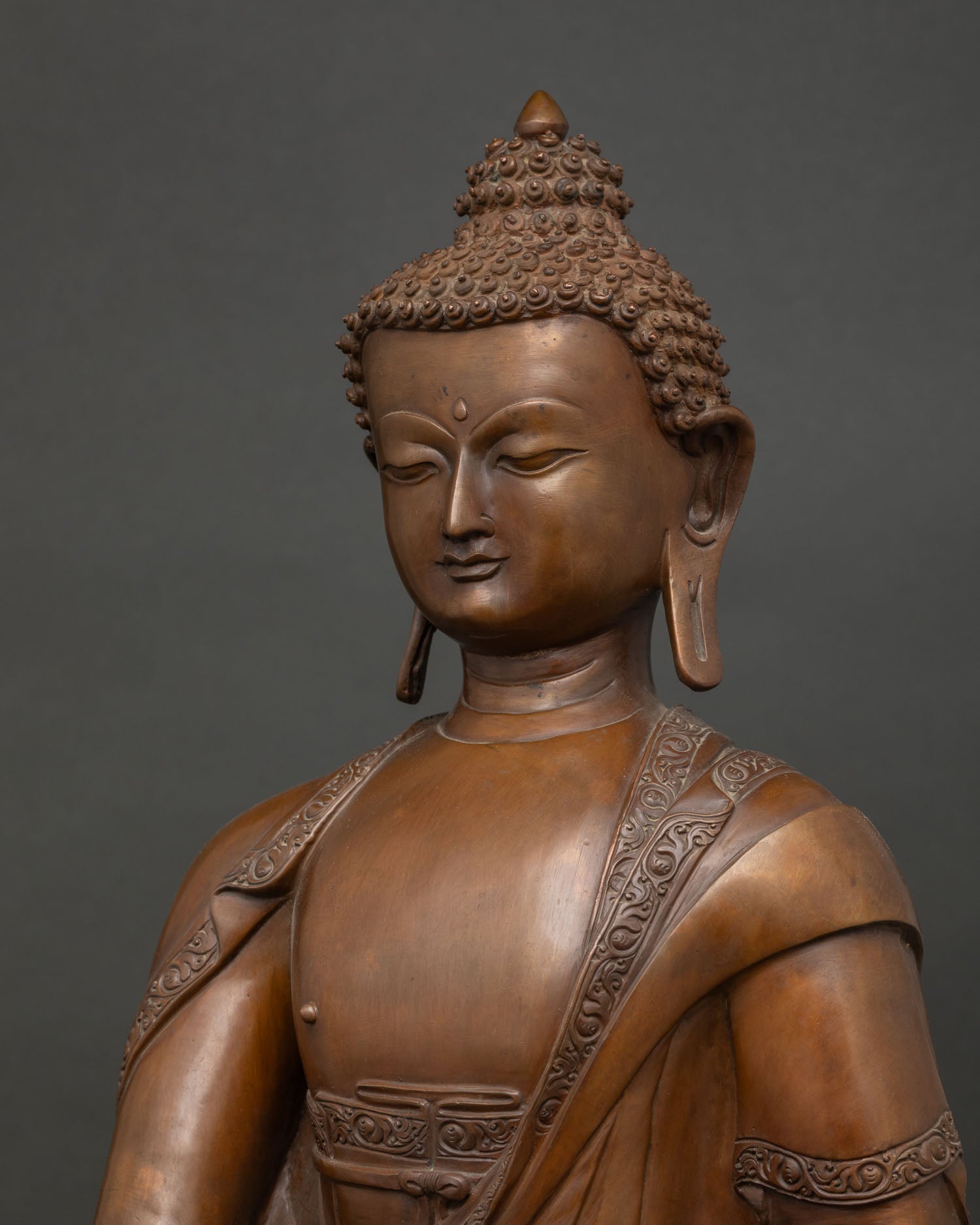 Detailed side close-up of Shakyamuni Buddha statue, oxidized copper craftsmanship