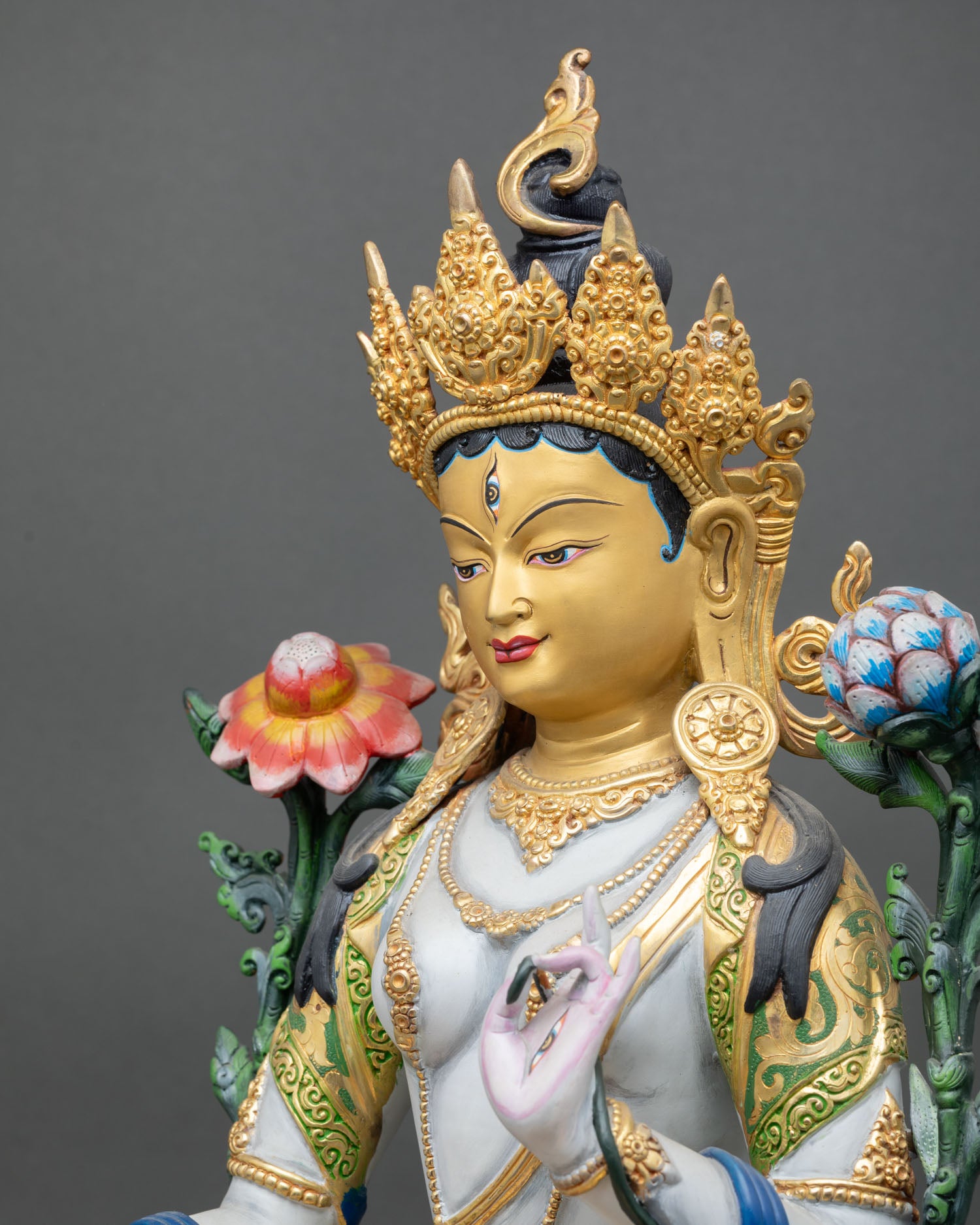 detailed side close-up of white tara statue with utpala flower and lotus base