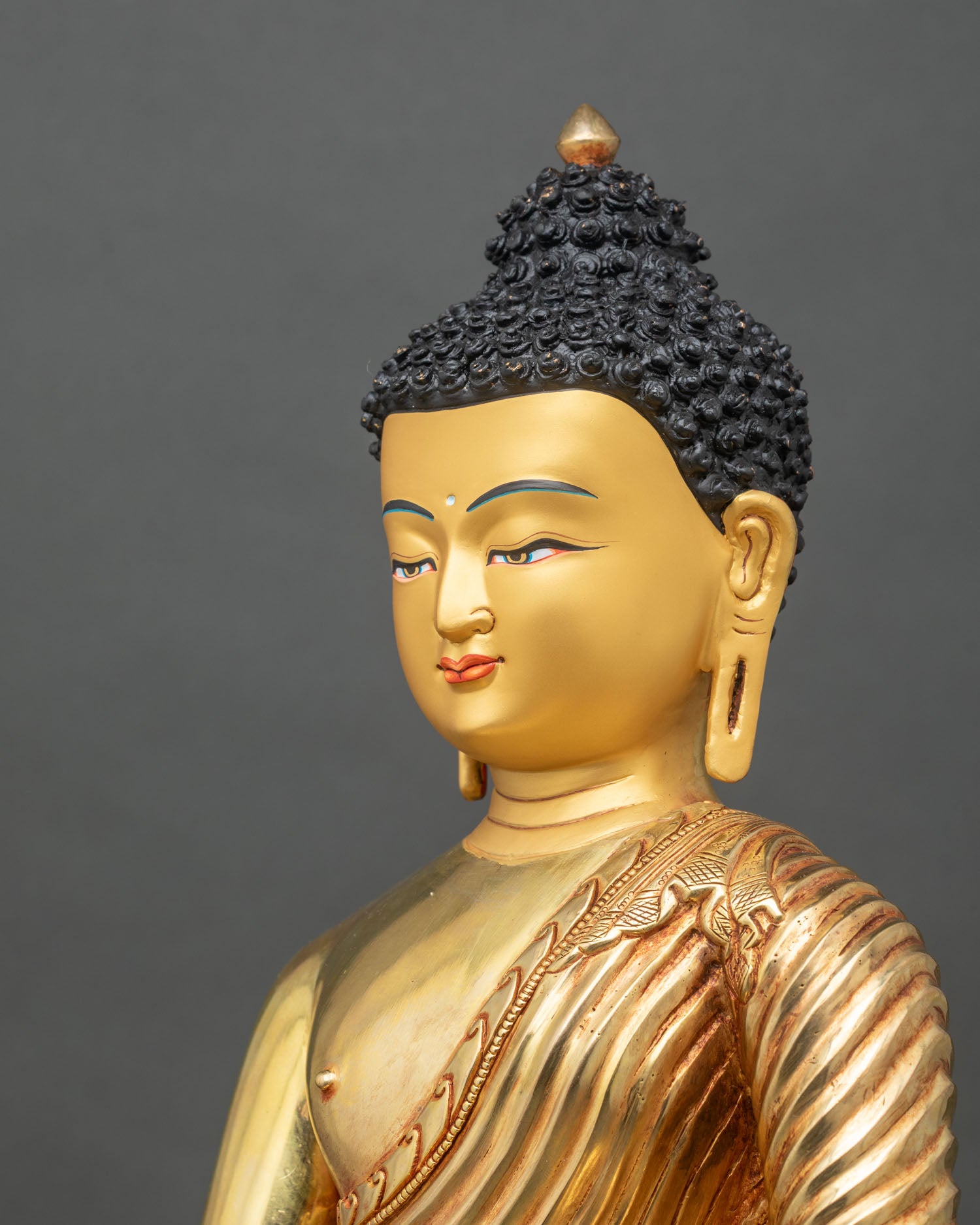 Detailed side close-up of Shakyamuni Buddha statue with intricate robe folds and lotus seat