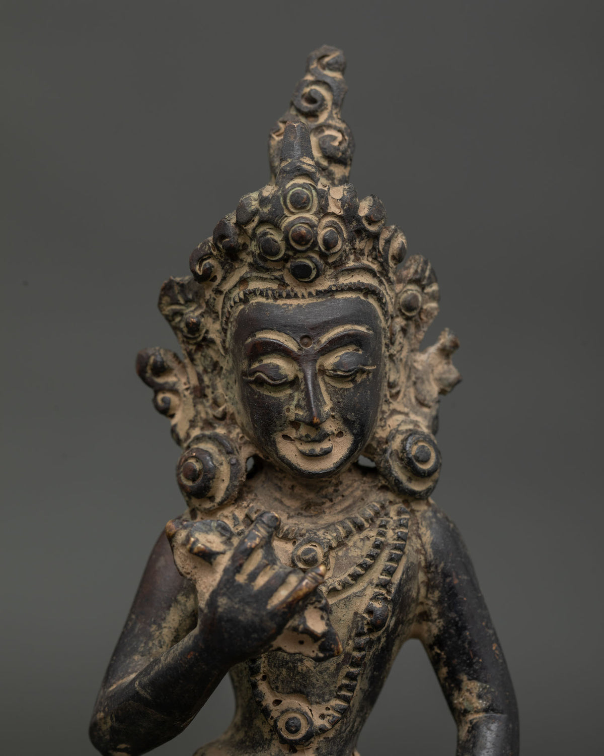 Detailed Vajrasattva statue face and ornaments with antique copper finish.