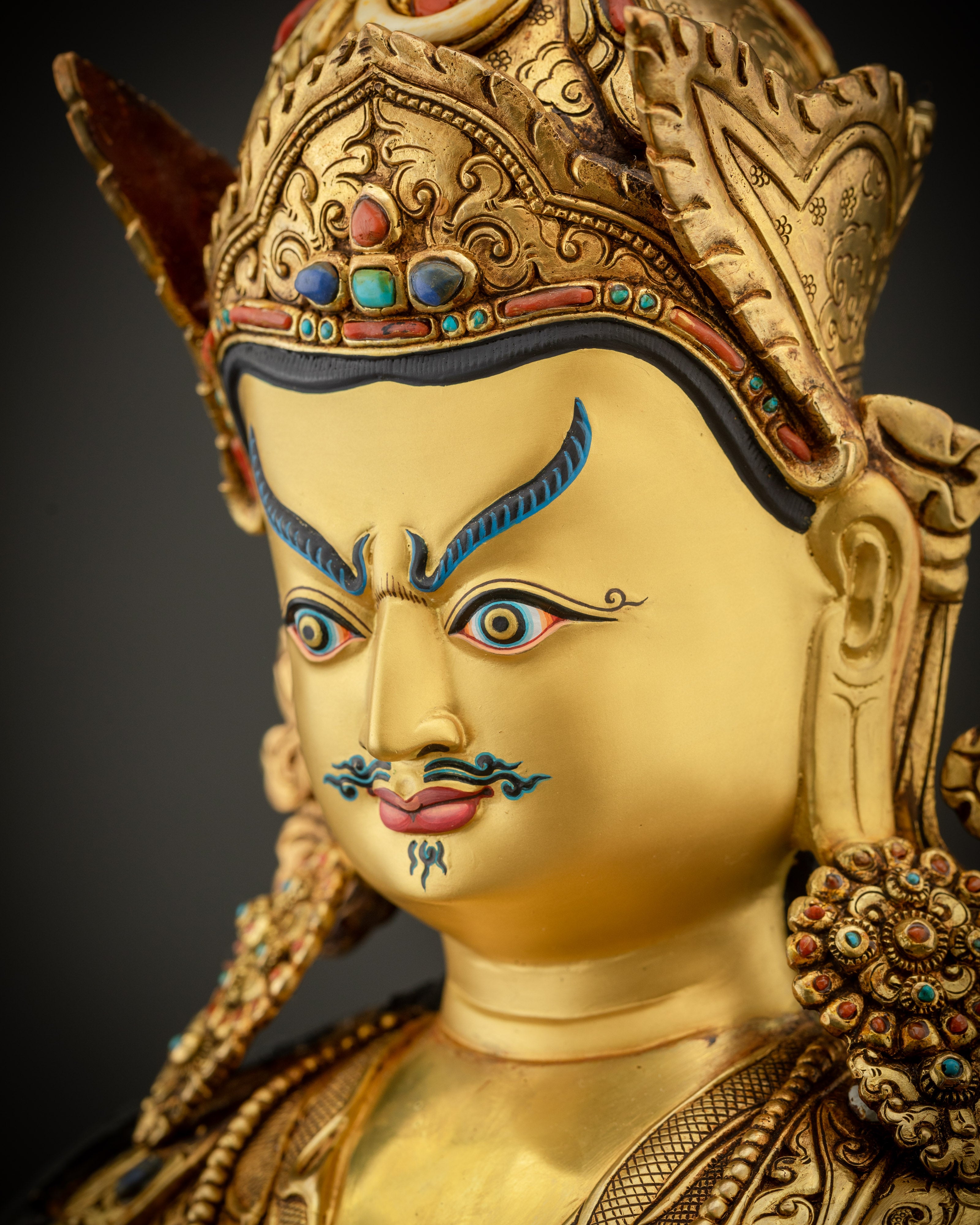 detailed close up face of Padmasambhava statue gold gilded Guru Rinpoche sculpture Nepal