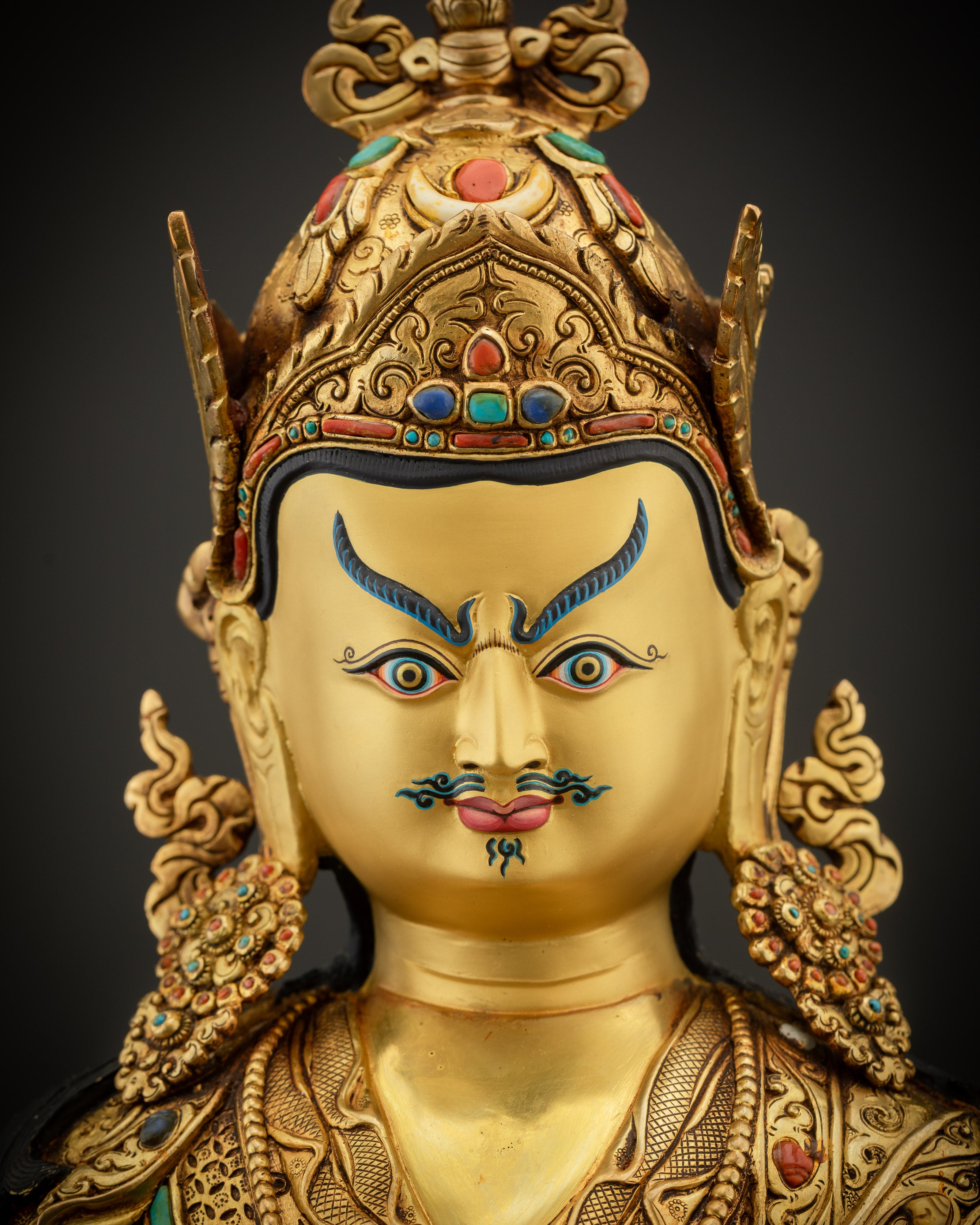 detailed close up face of Padmasambhava statue gold gilded Guru Rinpoche sculpture Nepal