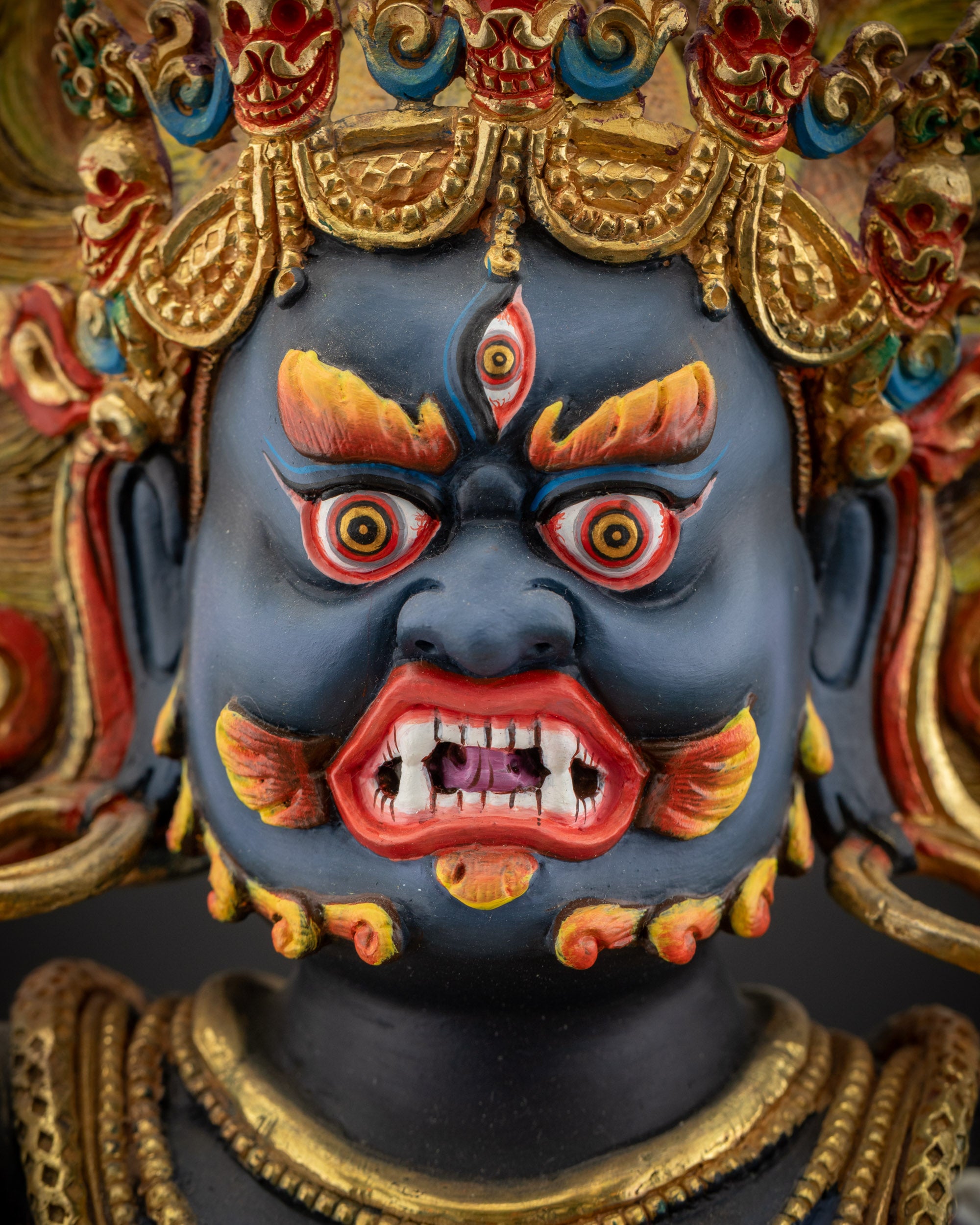 detailed close up of face Vajrapani statue with piercing eyes and red eyebrows, beard