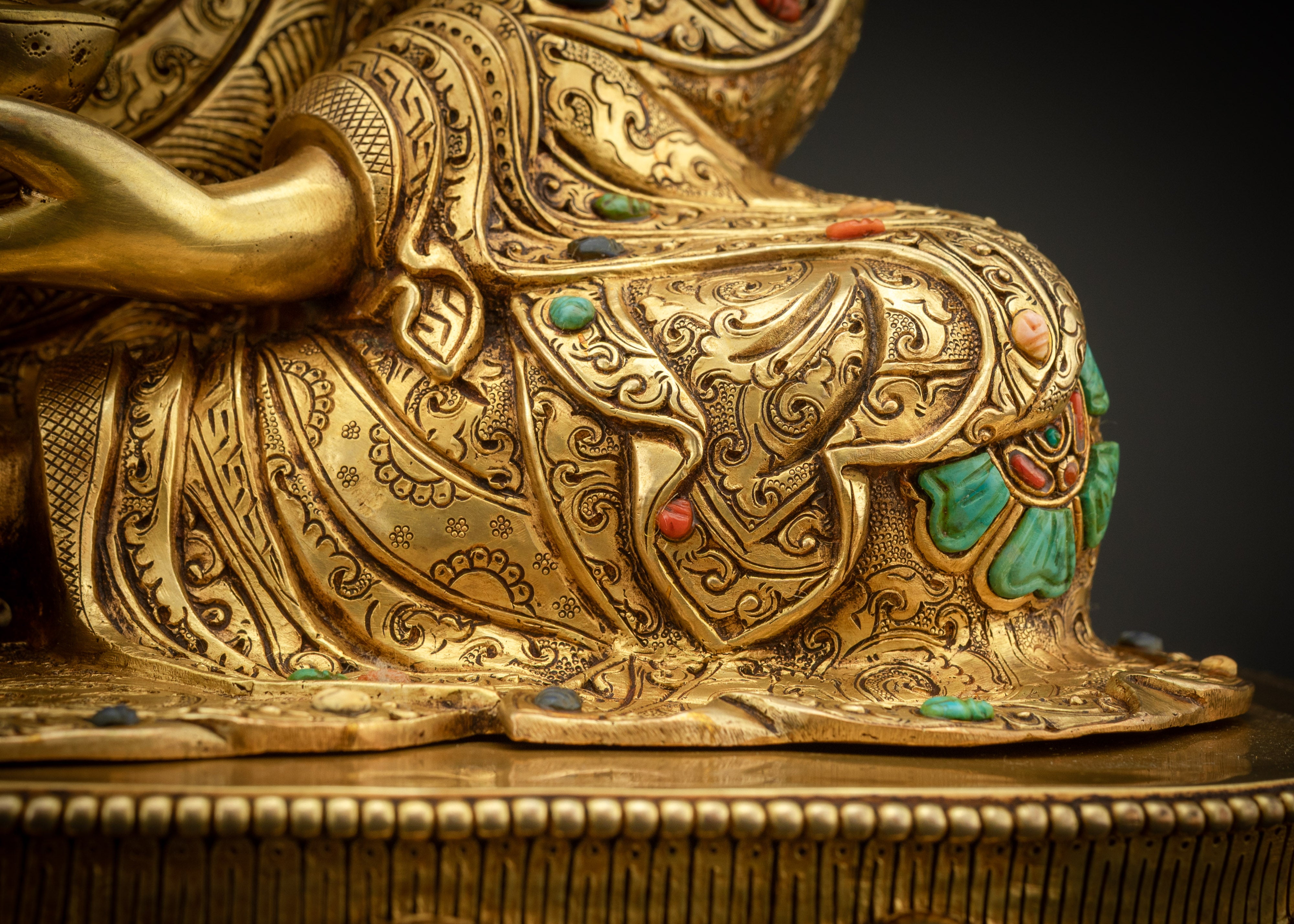 detailed shot of seated on lotus seat Padmasambhava statue gold fire gilded Buddhist art