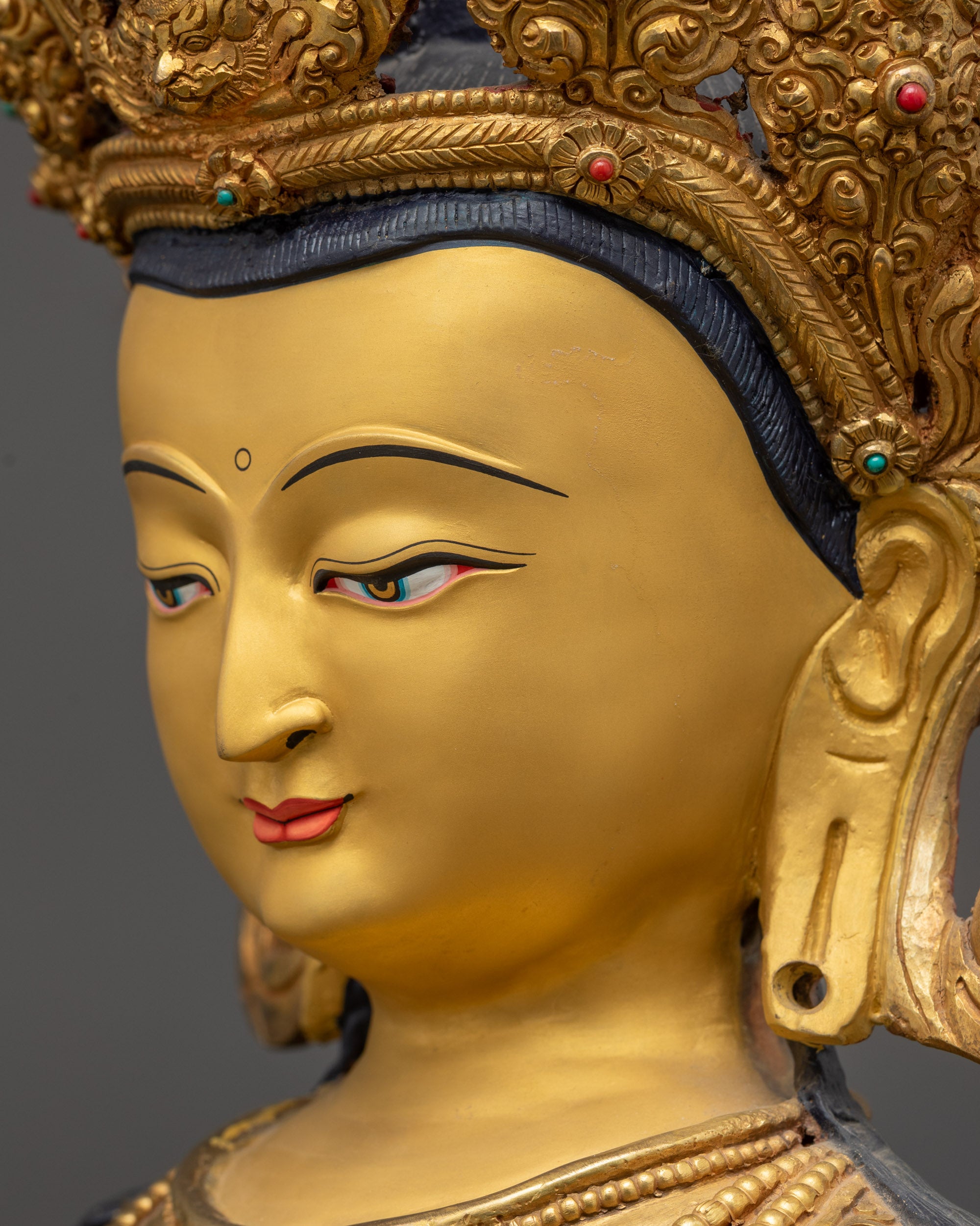 detailed side close up face Vajrasattva statue with serene gold-gilded gaze