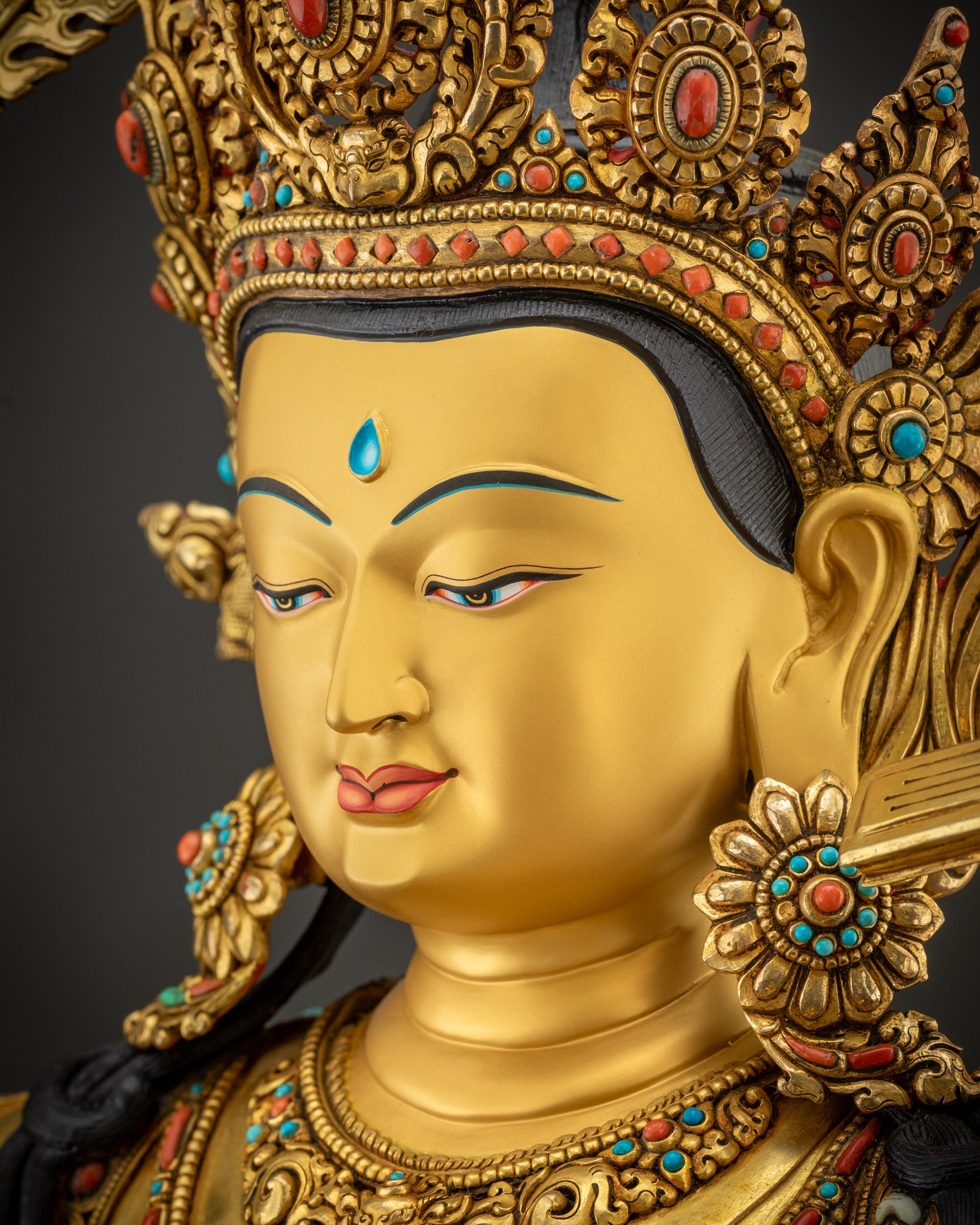 detailed side close up of face Manjushri gold-gilded copper alloy artwork