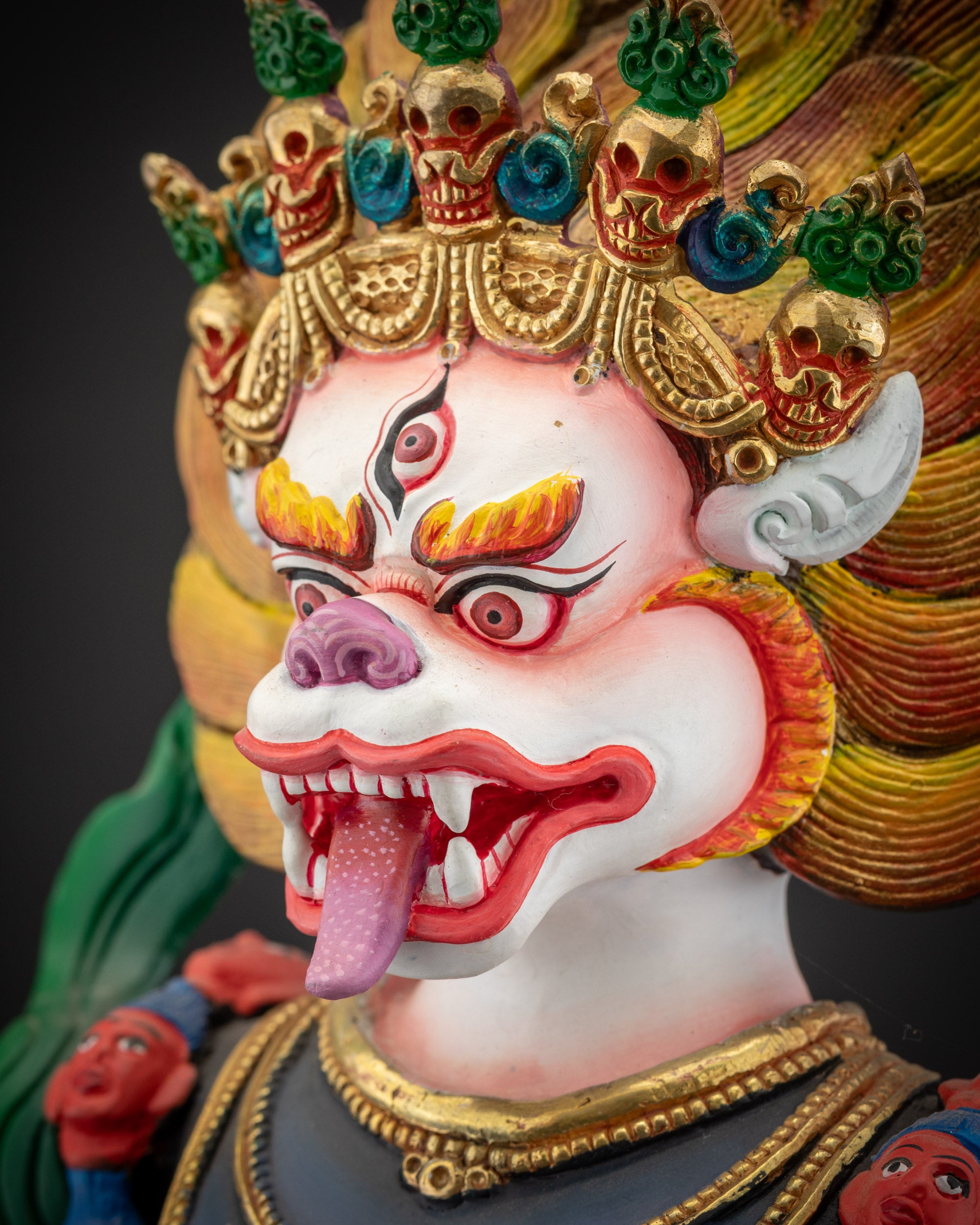 detailed side close up of face Simha Mukha statue with expressive features and gold accents