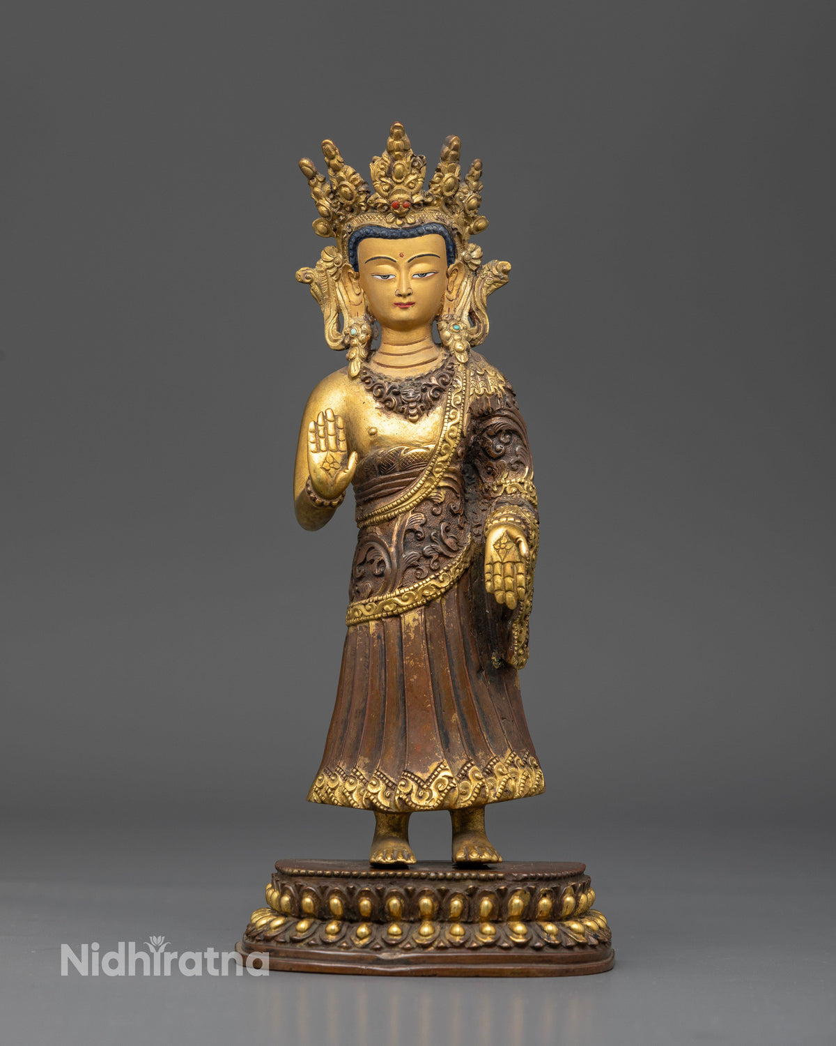 Dipankara Buddha Statue handcrafted by Newari artisans in Patan Nepal featuring an oxidized copper finish and gold gilded details.