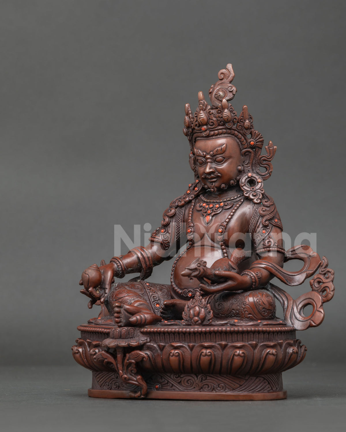 Dzambhala holding citron fruit and jewel spitting mongoose symbolizing generosity wealth and abundance.