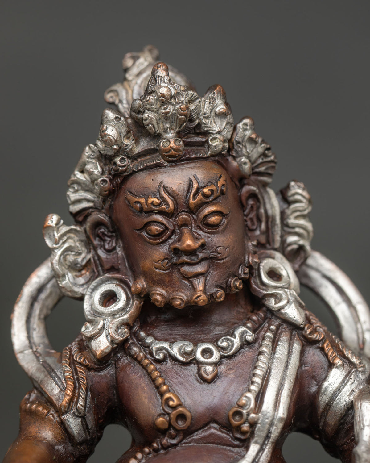 Dzambhala statue detailed face and hand carved floral ornamentation.