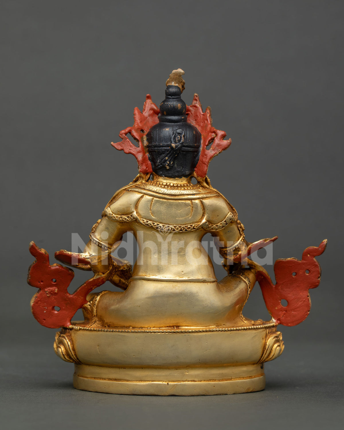 Dzambhala statue featuring ornate face and sacred lotus pedestal.