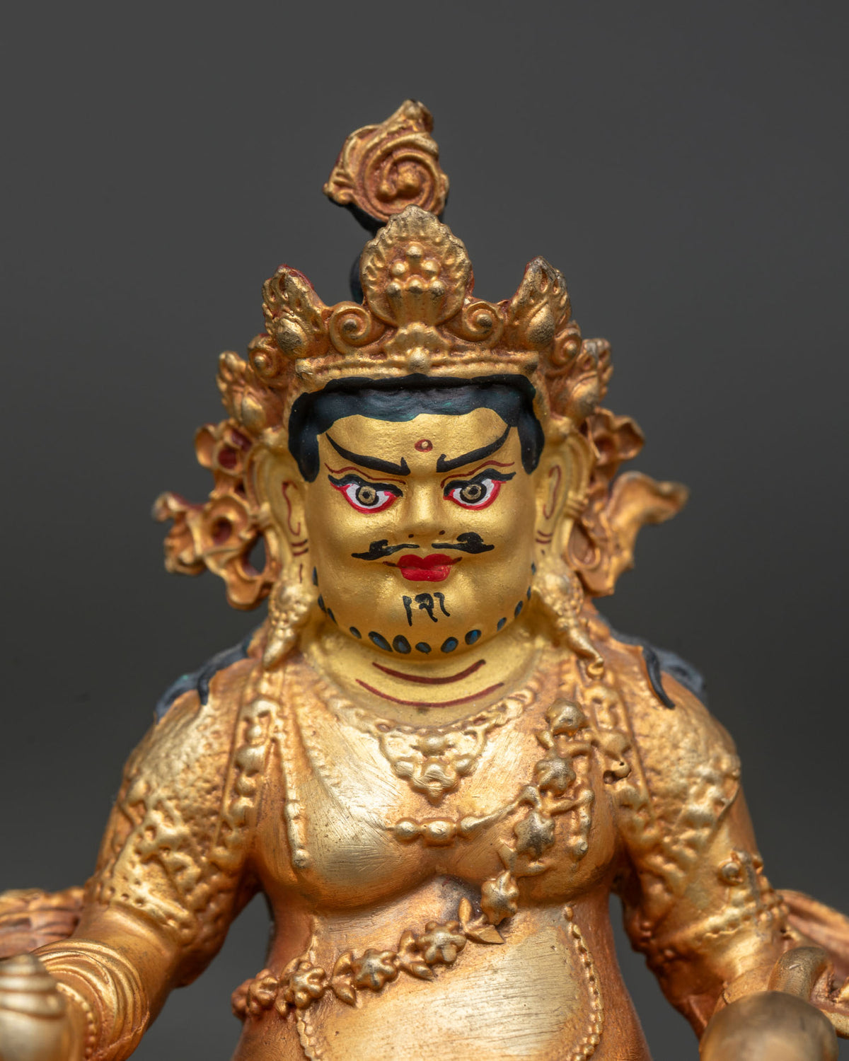 Dzambhala statue gold painted face and powerful semi wrathful expression.