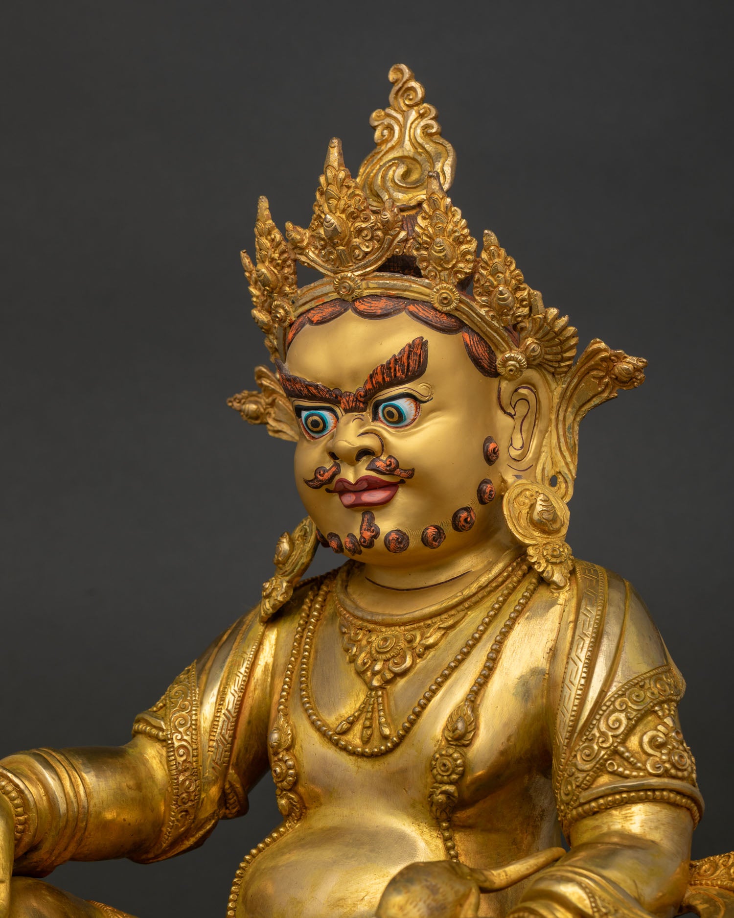 Dzambhala Statue Gold Painted Face Side Close Up with Serene Wealth Deity Expression
