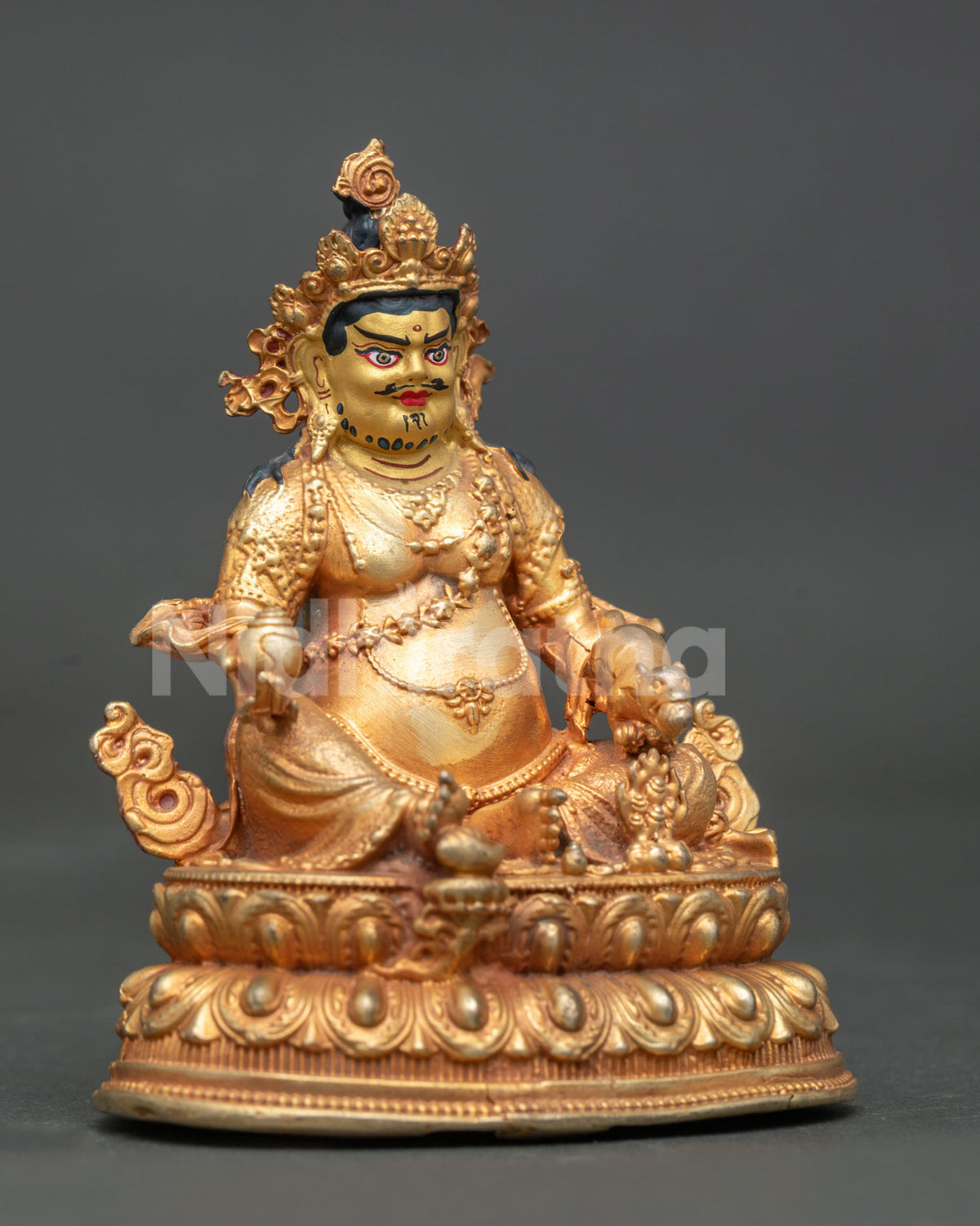 Dzambhala statue holding citron fruits and jewel spitting mongoose.