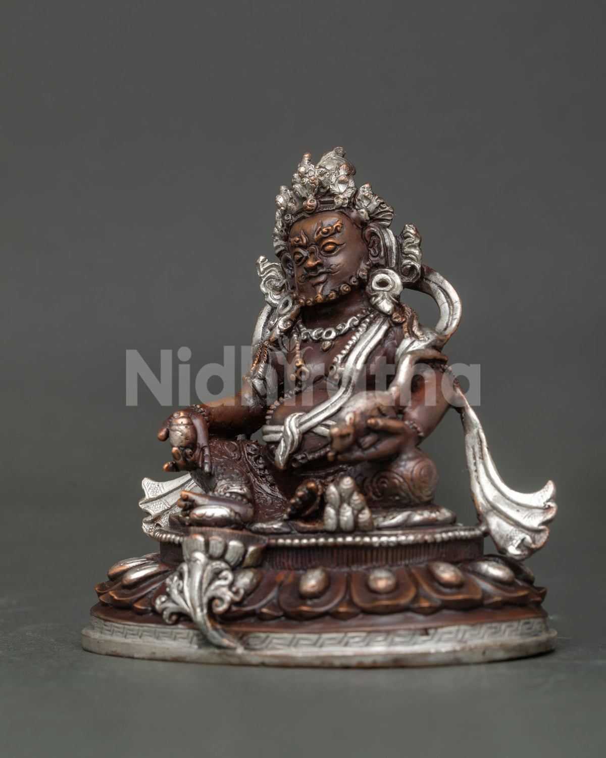Dzambhala statue holding jewel spitting mongoose with intricate floral motifs.