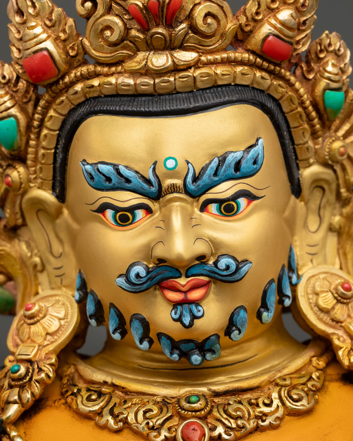 Dzambhala statue, semi wrathful expression, gold gilded face, semi precious stones, detailed himalayan metal craft