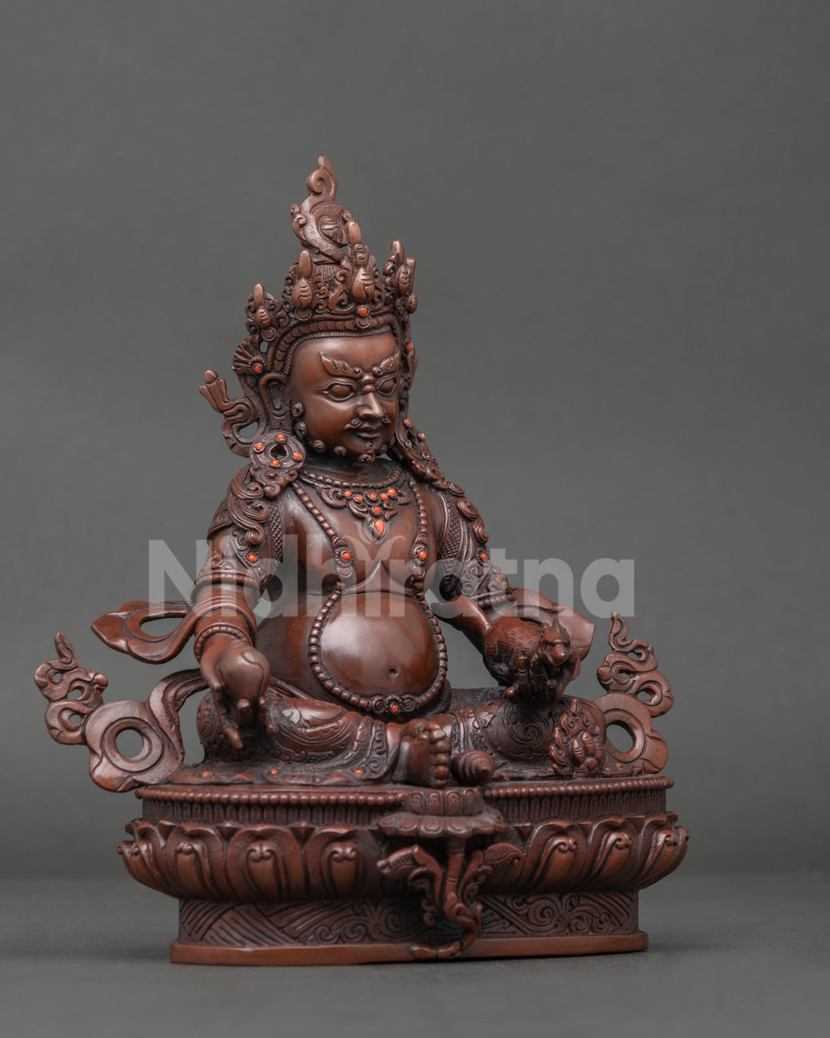 Dzambhala statue with semi precious coral stones and hand carved lotus pedestal seated on sacred conch.