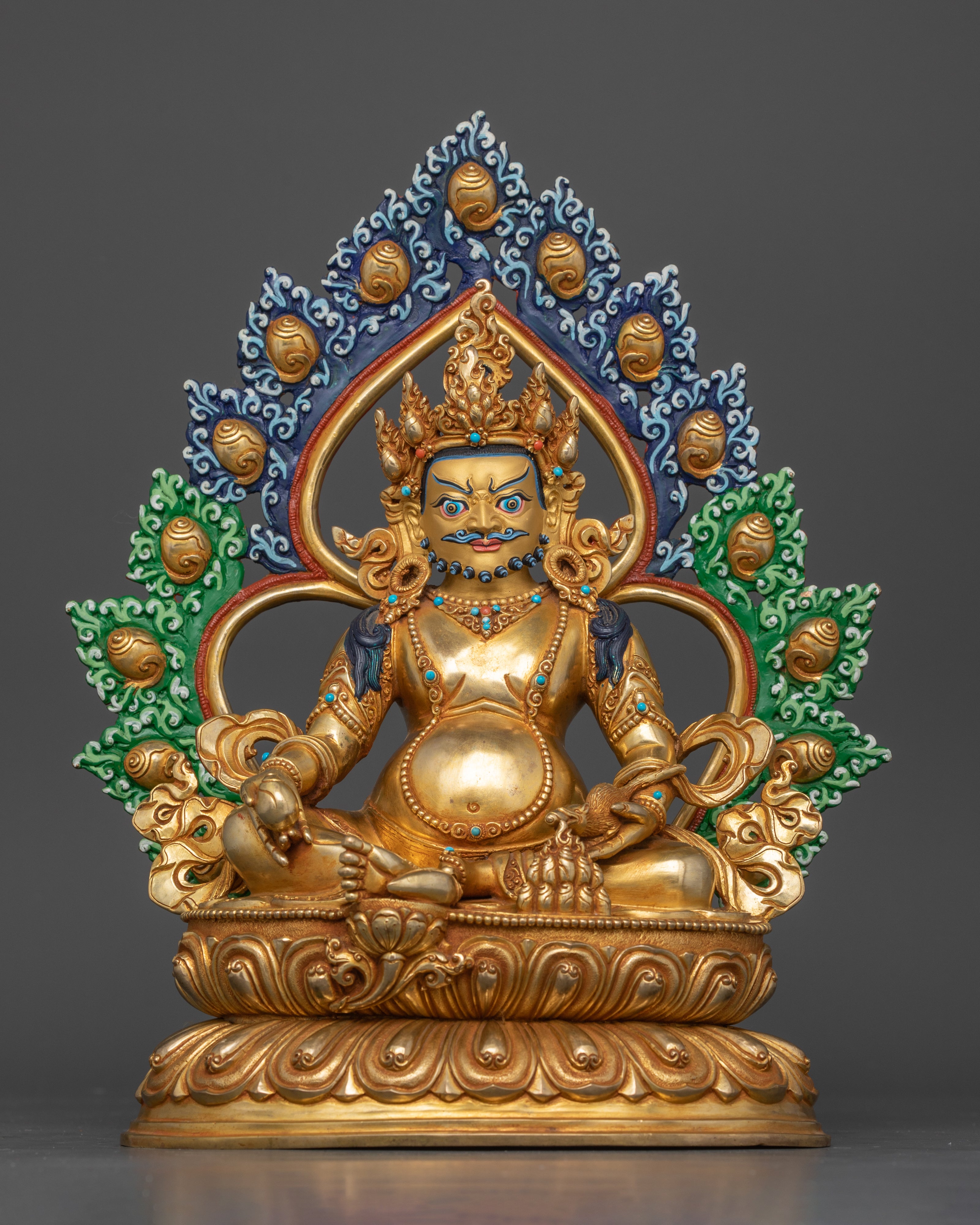 gold plated dzambhala statue adorned with gemstones and painted green and blue