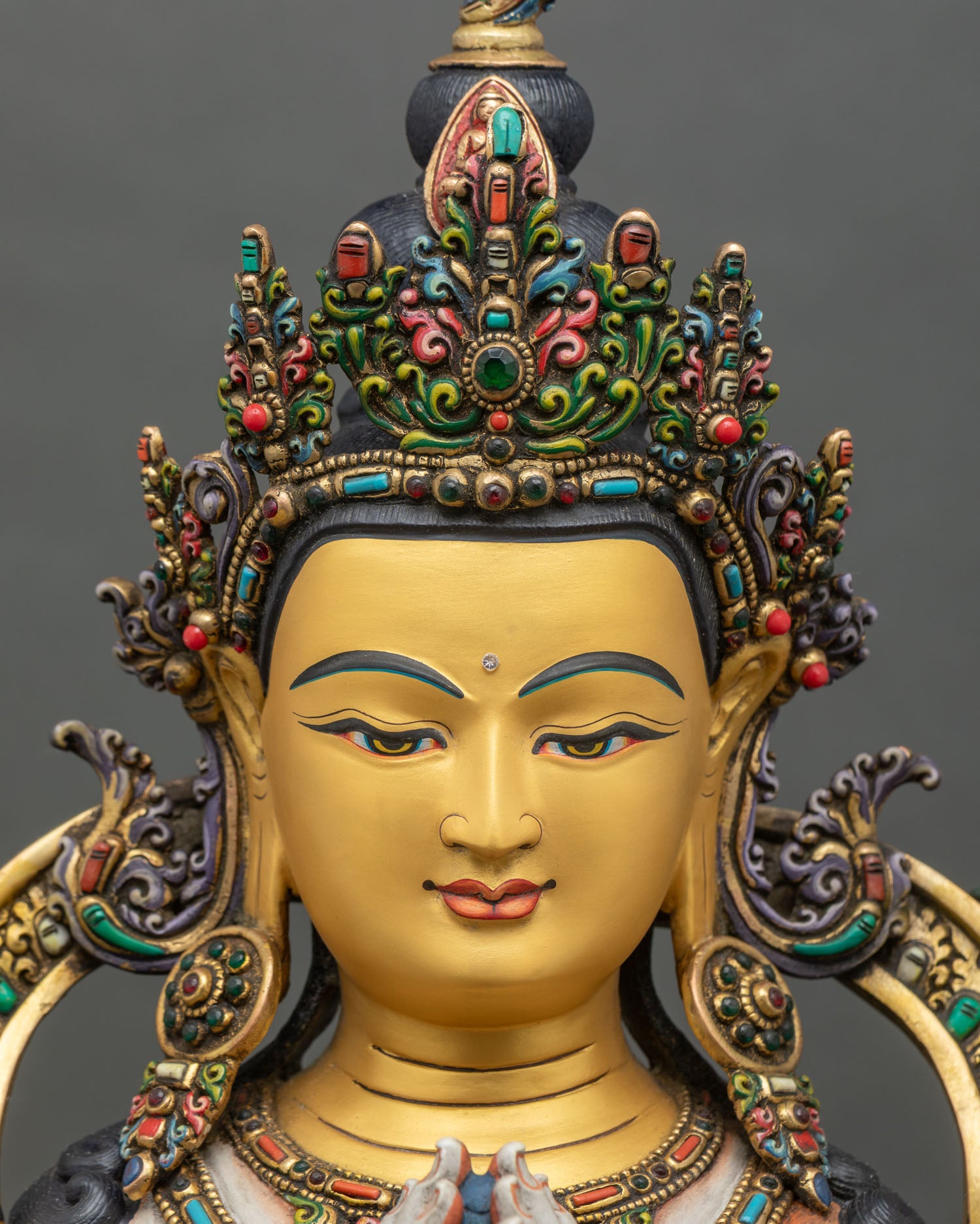 Face close-up of Chenrezig Avalokiteshvara statue with serene gold-painted expression