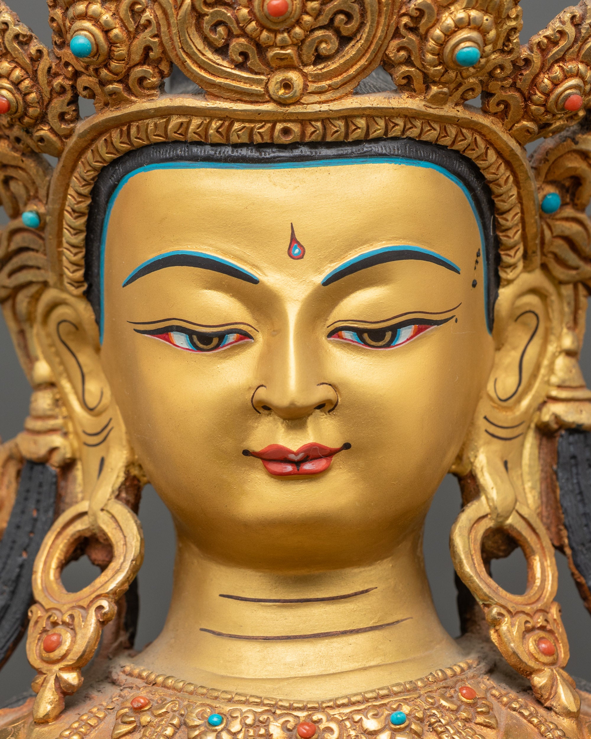 face close up of maitreya buddha statue, serene expression, gold painted face