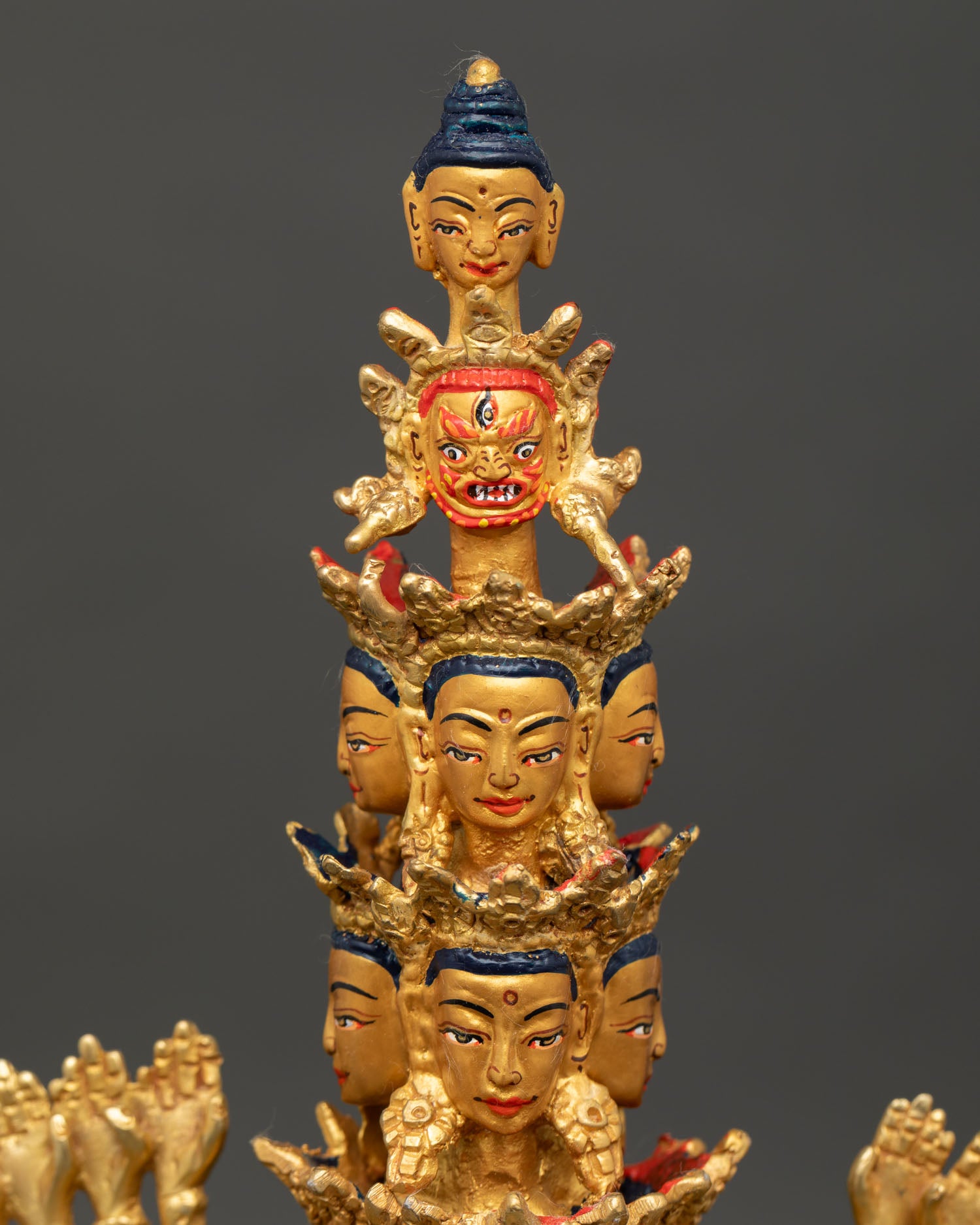 face close up of 1000 armed avalokiteshvara statue with serene gold painted expression