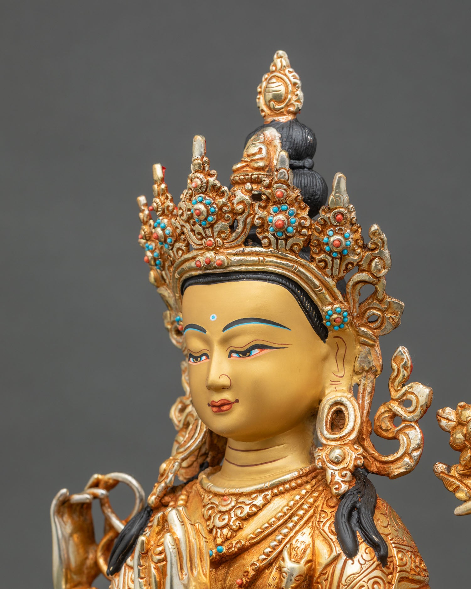 Face close-up of Chenrezig statue with serene expression and hand-painted 24K gold finish