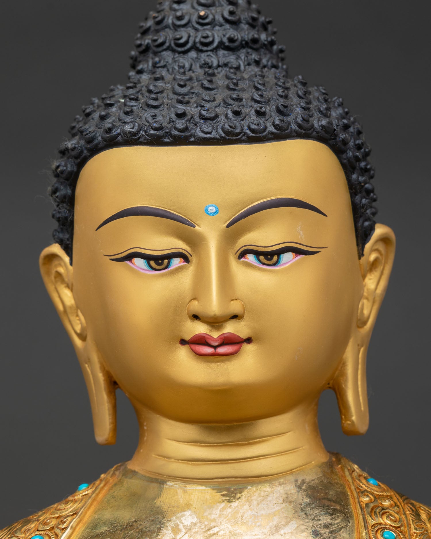 face close up shakyamuni buddha statue, serene gold-painted expression, buddhist art nepal