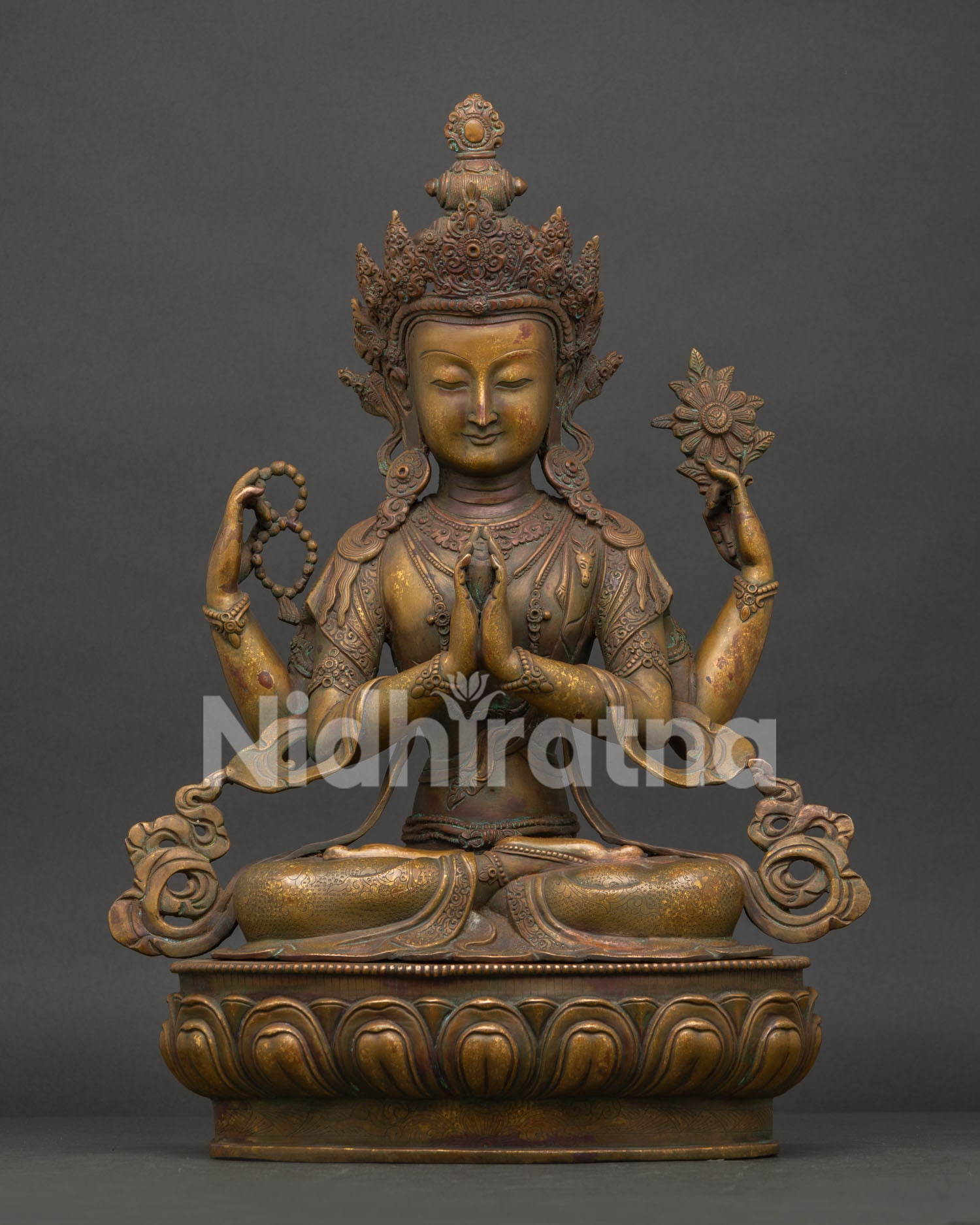 Four Armed Chenrezig statue handcrafted from oxidized copper seated on lotus pedestal in Nepal.