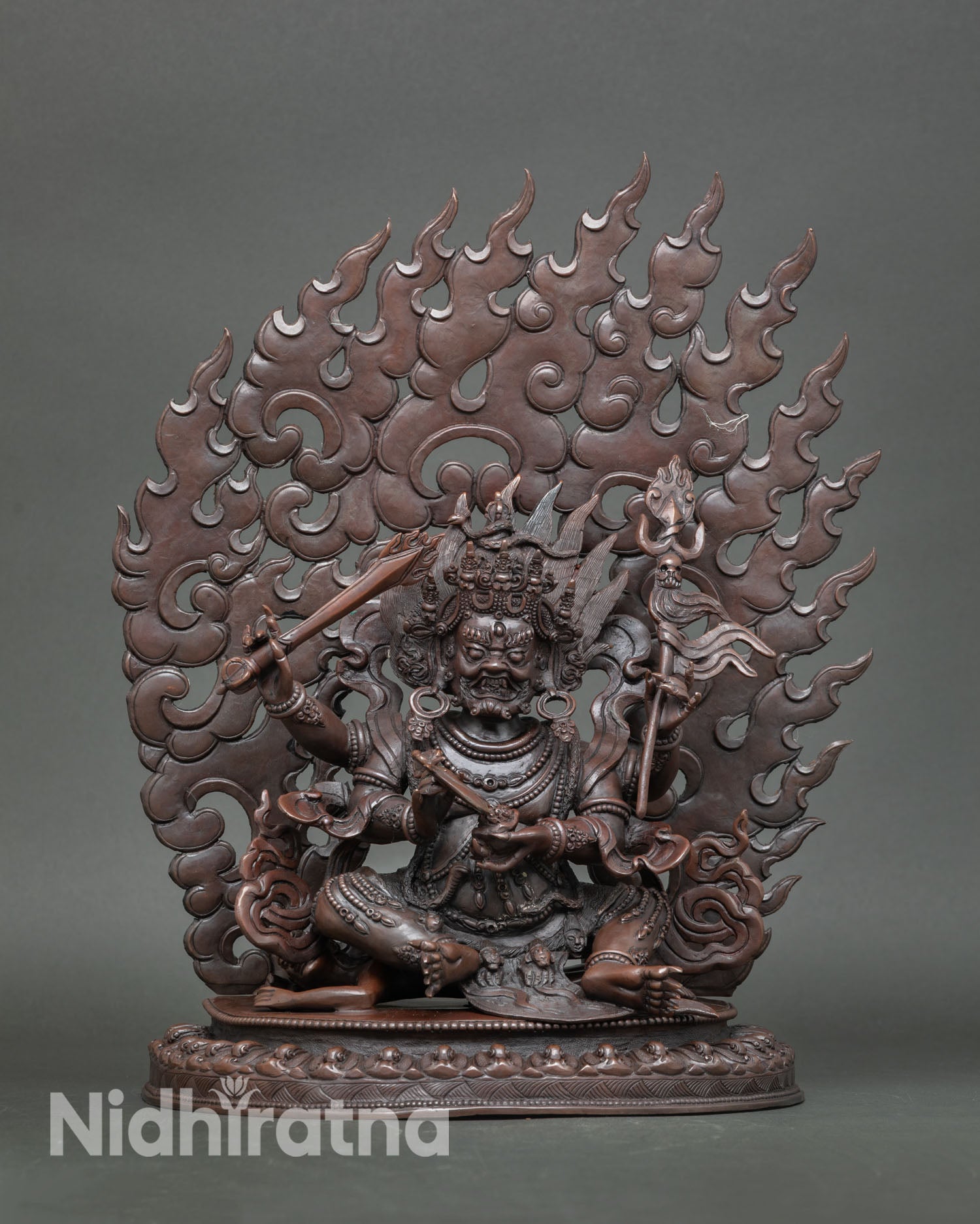 Four Armed Mahakala statue front view copper sculpture with oxidized finish handmade in Nepal by skilled Newari artisan showing wrathful protector deity on lotus base.