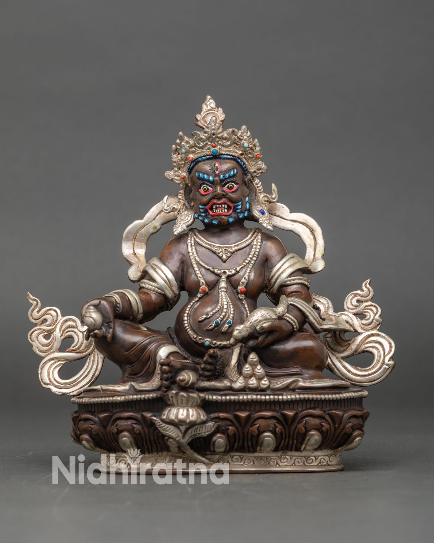 Front view of a Dzambhala statue handcrafted in oxidized silver-plated copper from Nepal.