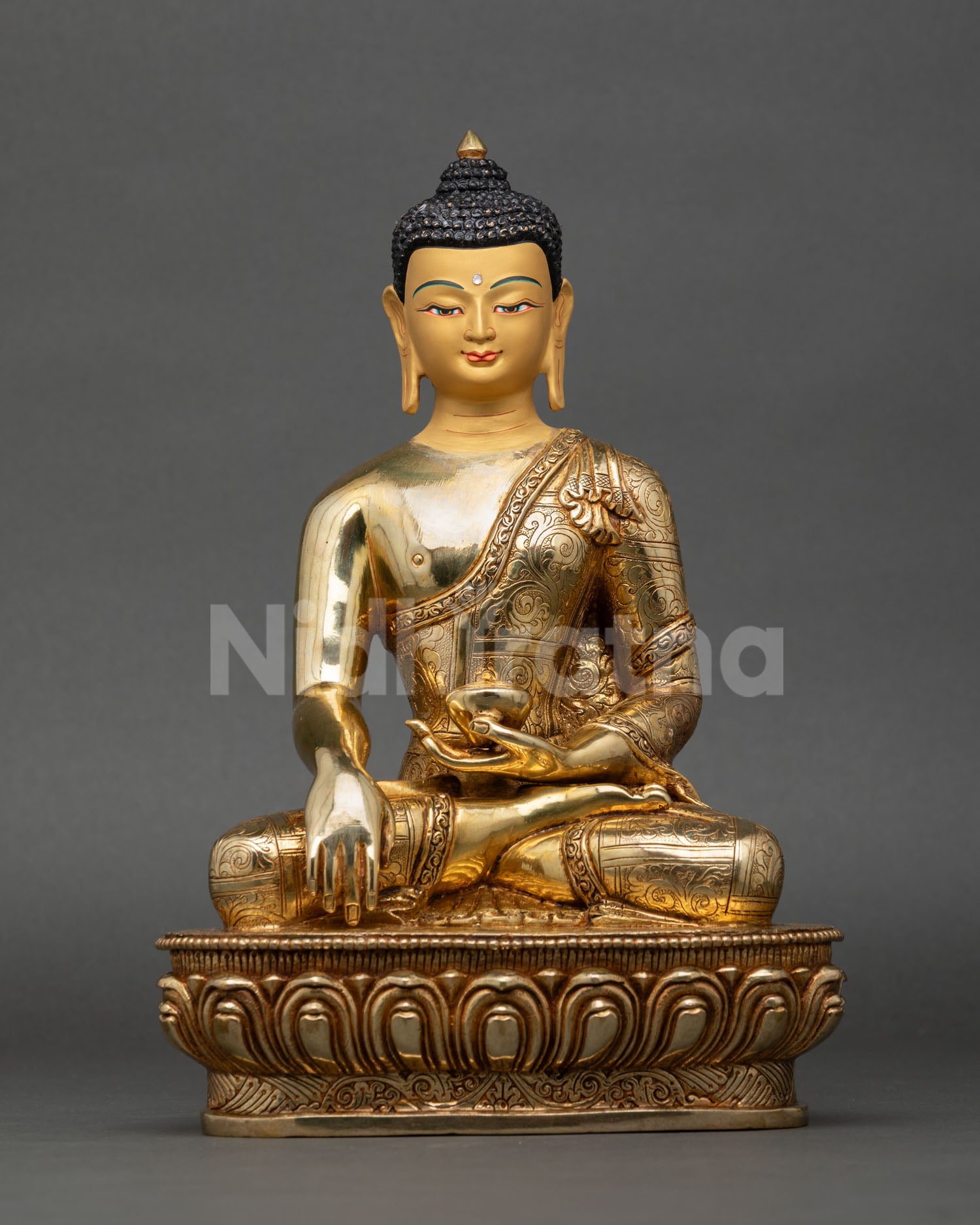 Front view of handcrafted Shakyamuni Buddha statue made of copper with gold gilding showing serene gold painted face and engraved monastic robe floral motifs