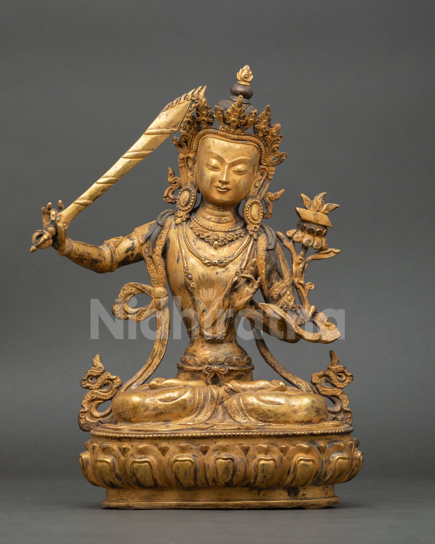 Front view of Manjushri statue handmade by Newari artist from Patan Nepal lost wax copper sculpture gold fire gilded antique finish seated on lotus pedestal