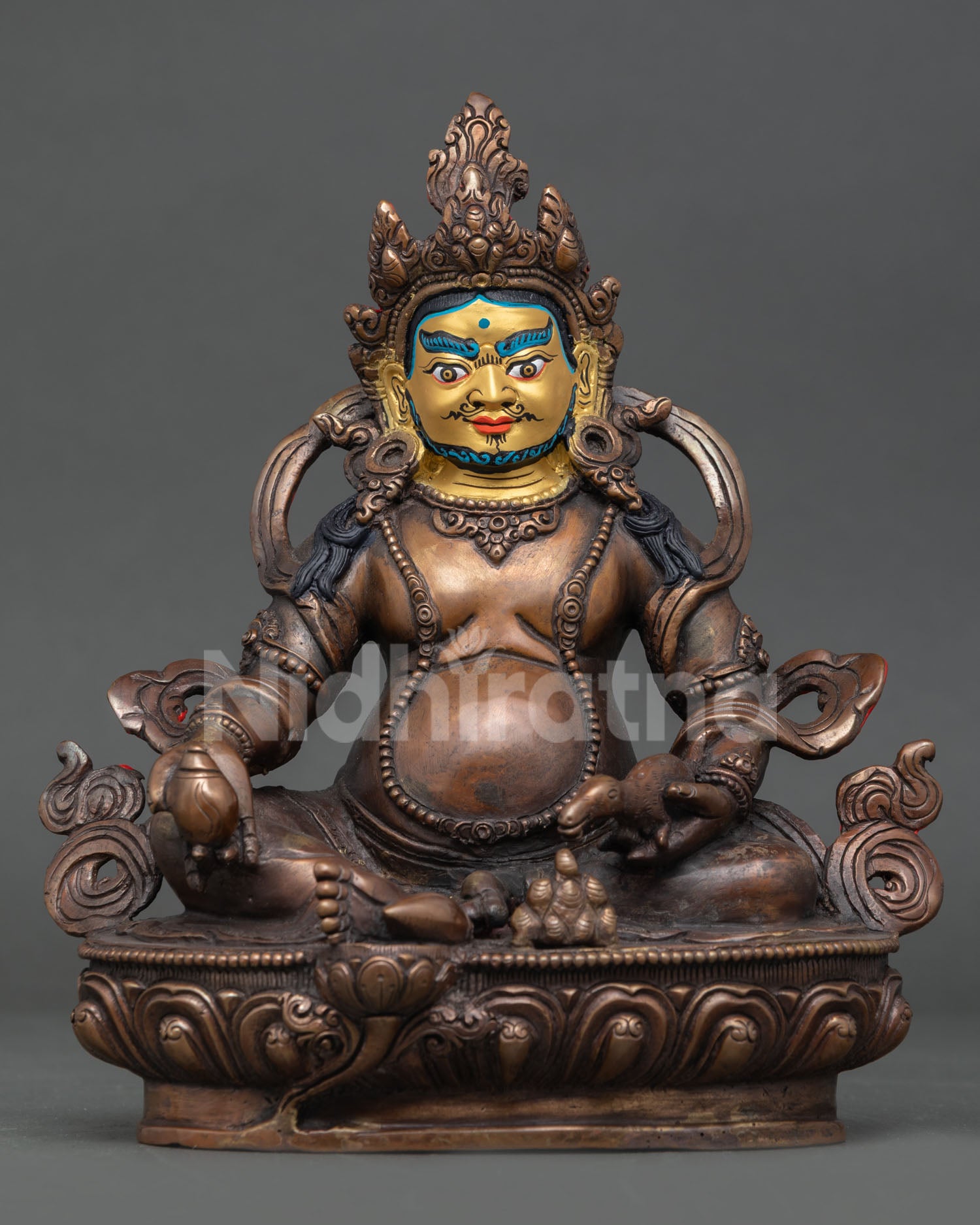 Front view of a handcrafted Dzambhala statue in oxidized copper with a beautifully gold-painted face.