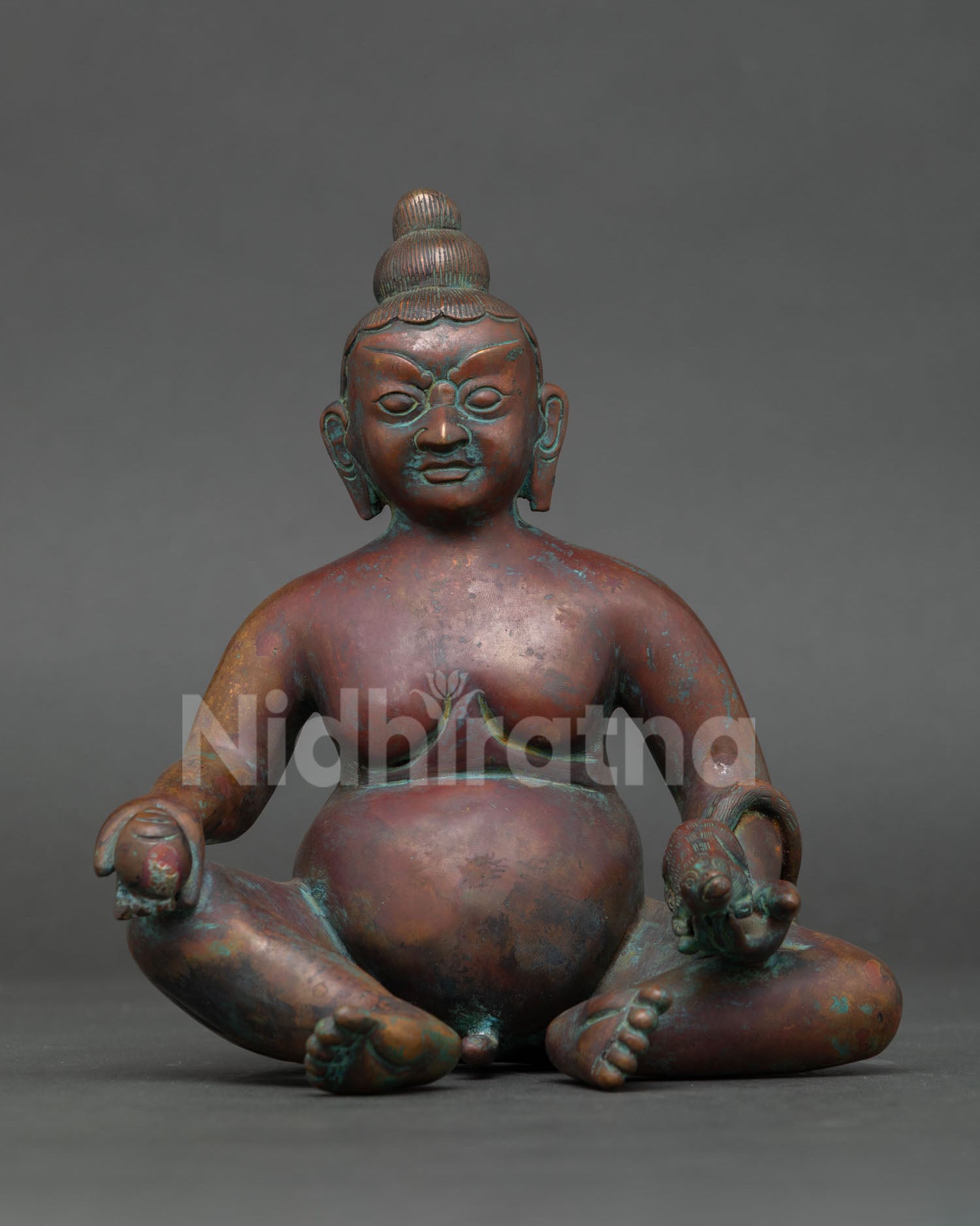 front view of dzambhala statue holding mongoose symbol of prosperity and abundance