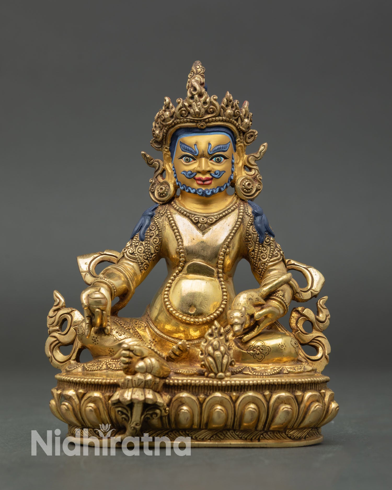 Front view of Dzambhala statue with gold painted face, copper body, and semi precious stones from Nepal.