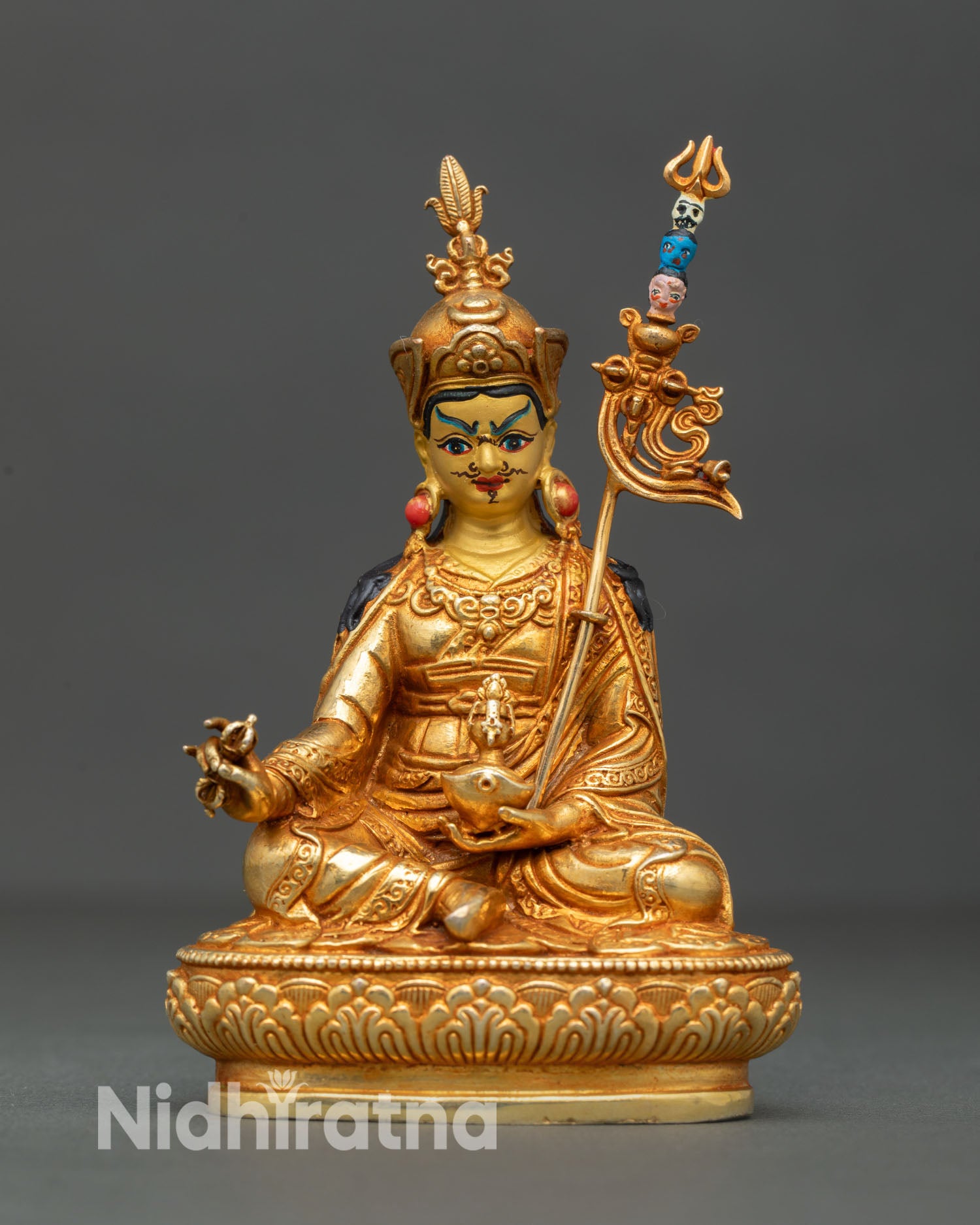 Front view of Guru Rinpoche statue handcrafted in Nepal by Newari artisans with gold gilded copper body serene gold painted face and detailed lotus seat Buddhist sculpture