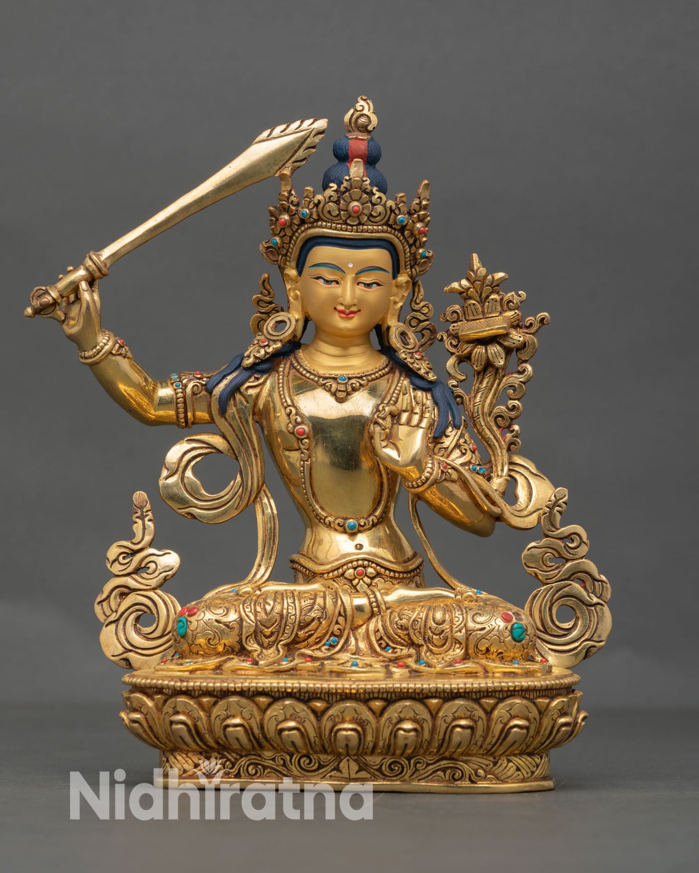 Front view of handcrafted Manjushree statue in gold gilded copper with serene face and lotus throne from Nepal