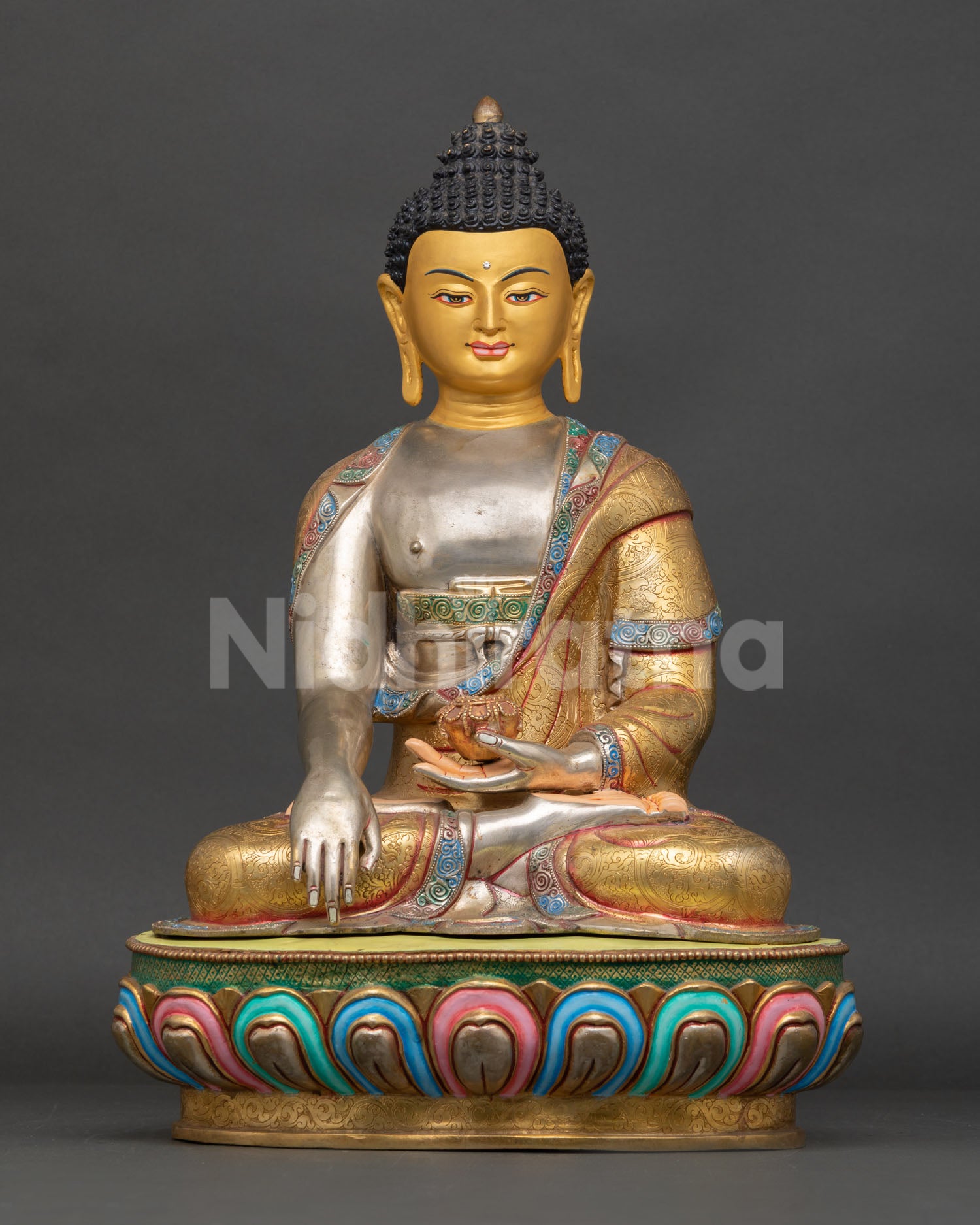 Front view of a handmade Buddha Shakyamuni statue from Nepal in copper with gold gilding, silver-plated details, and a multicolored lotus pedestal with a gold-painted face