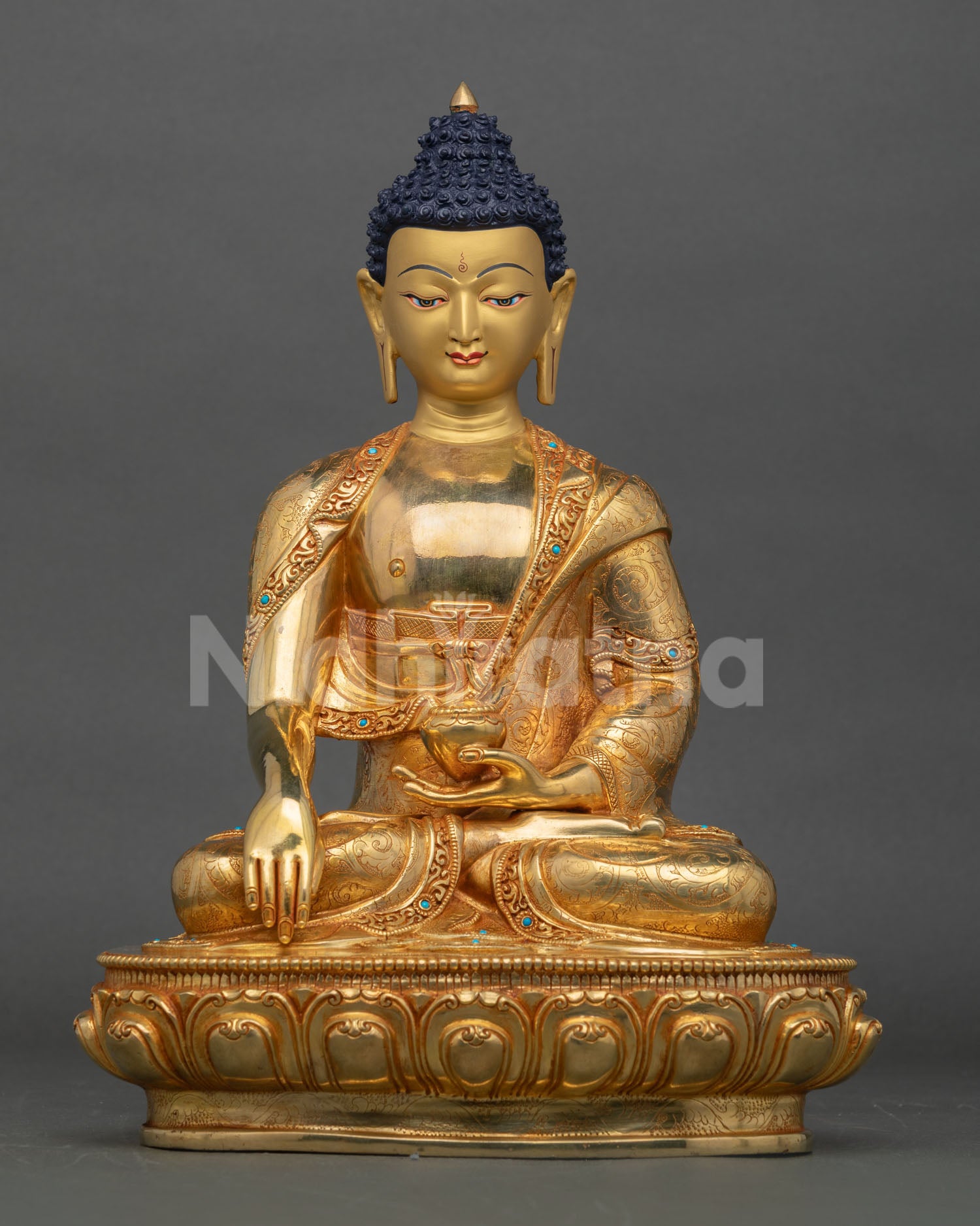 Front view of Handmade Shakyamuni Buddha statue seated on lotus pedestal in copper with gold gilding and turquoise stone embellished monastic robe