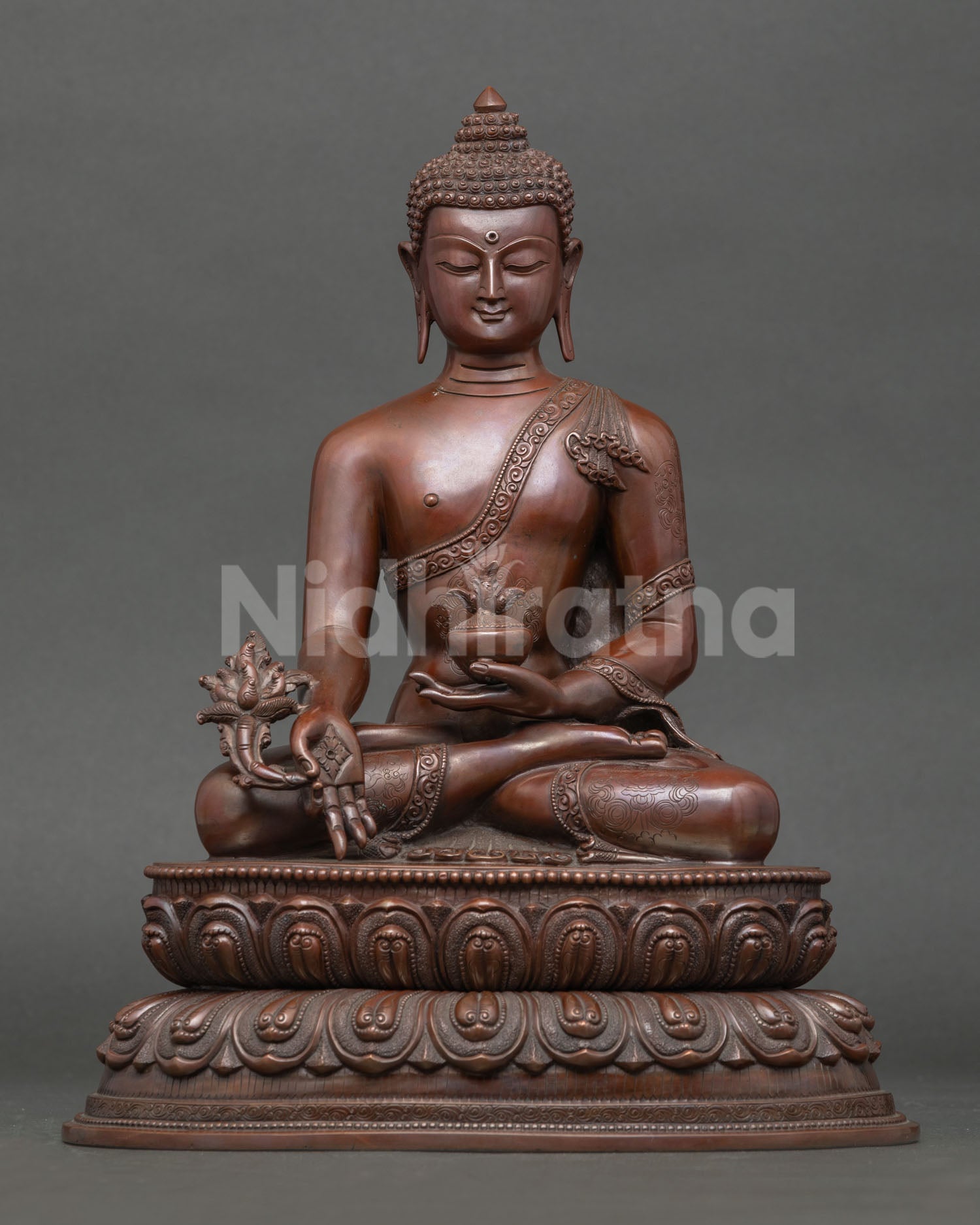 Front view of Medicine Buddha statue seated on lotus base with healing bowl from Nepal