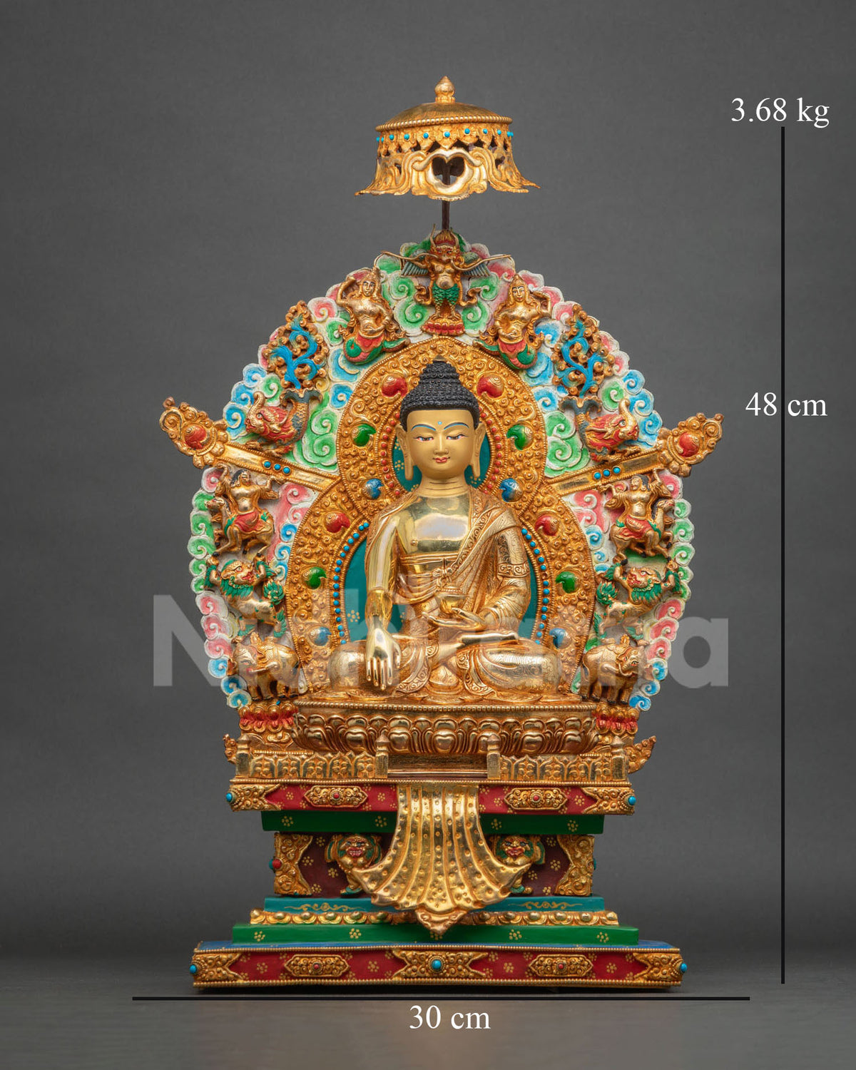 Front view of Shakyamuni Buddha statue on ornate throne with multicolor halo and parasol