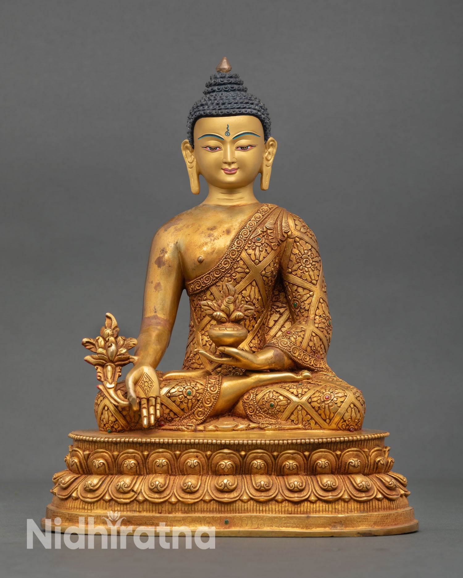 Front view of Tibetan Medicine Buddha statue handcrafted in Nepal with 24K gold fire gilded copper body serene gold painted face and lotus meditation posture