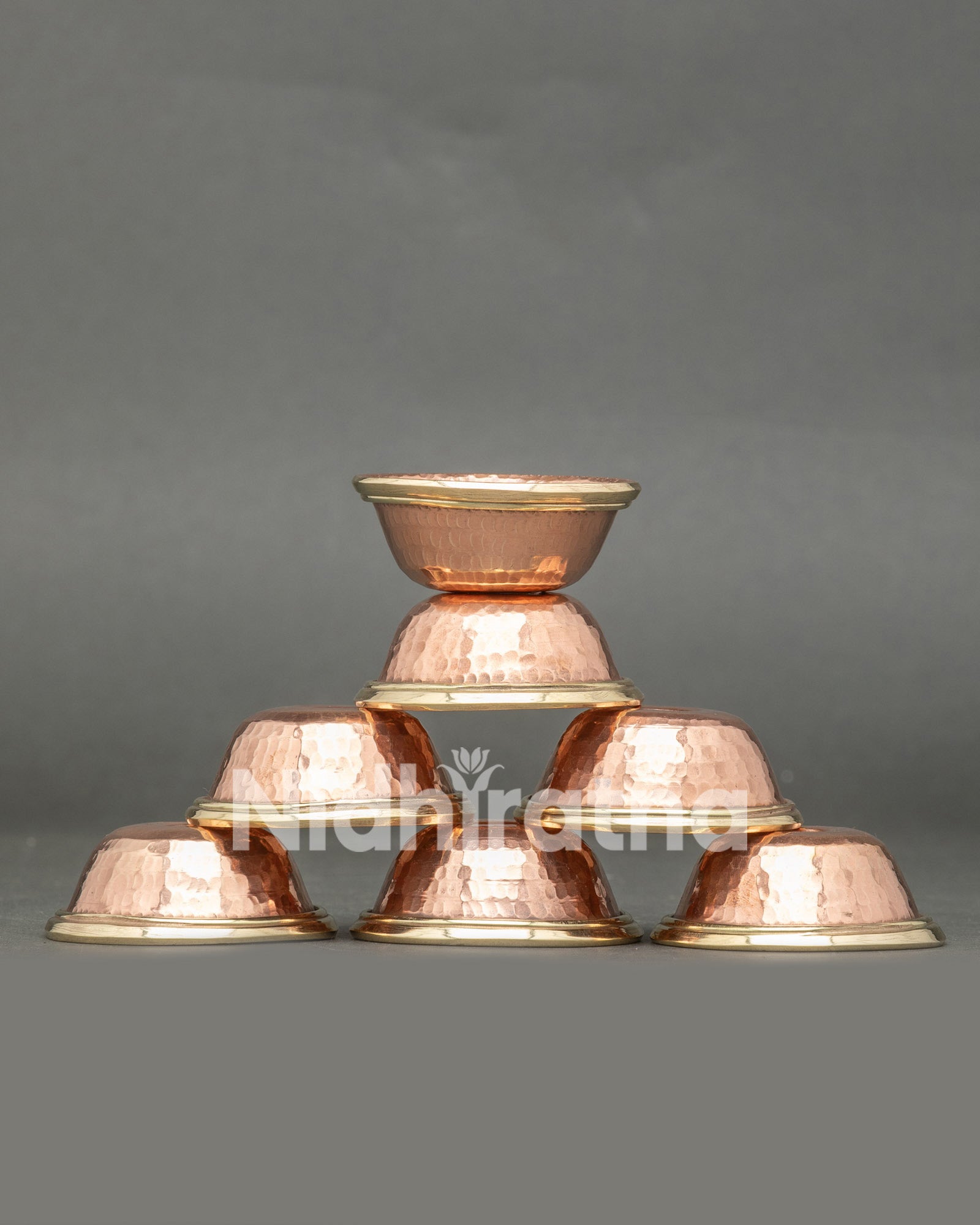 Front view seven handcrafted copper water offering bowls from Patan Nepal