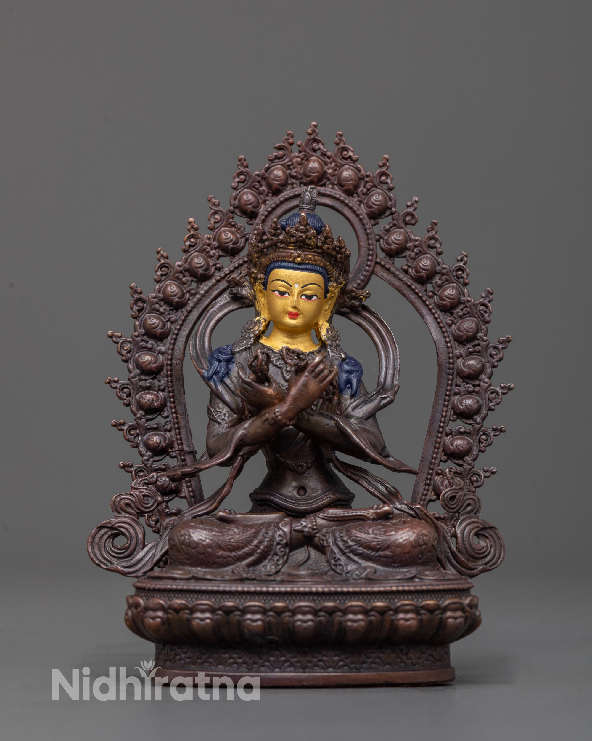 front view of Vajradhara statue with gold face and oxidized copper body on lotus base