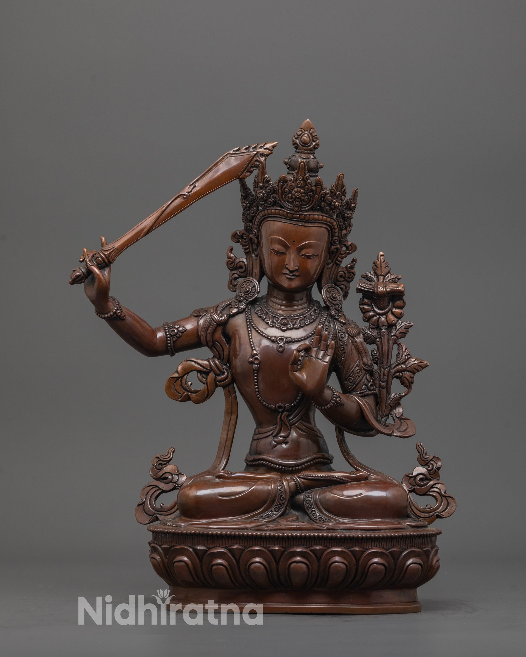front view of hand-carved Manjushri statue with oxidized copper and lotus base finish