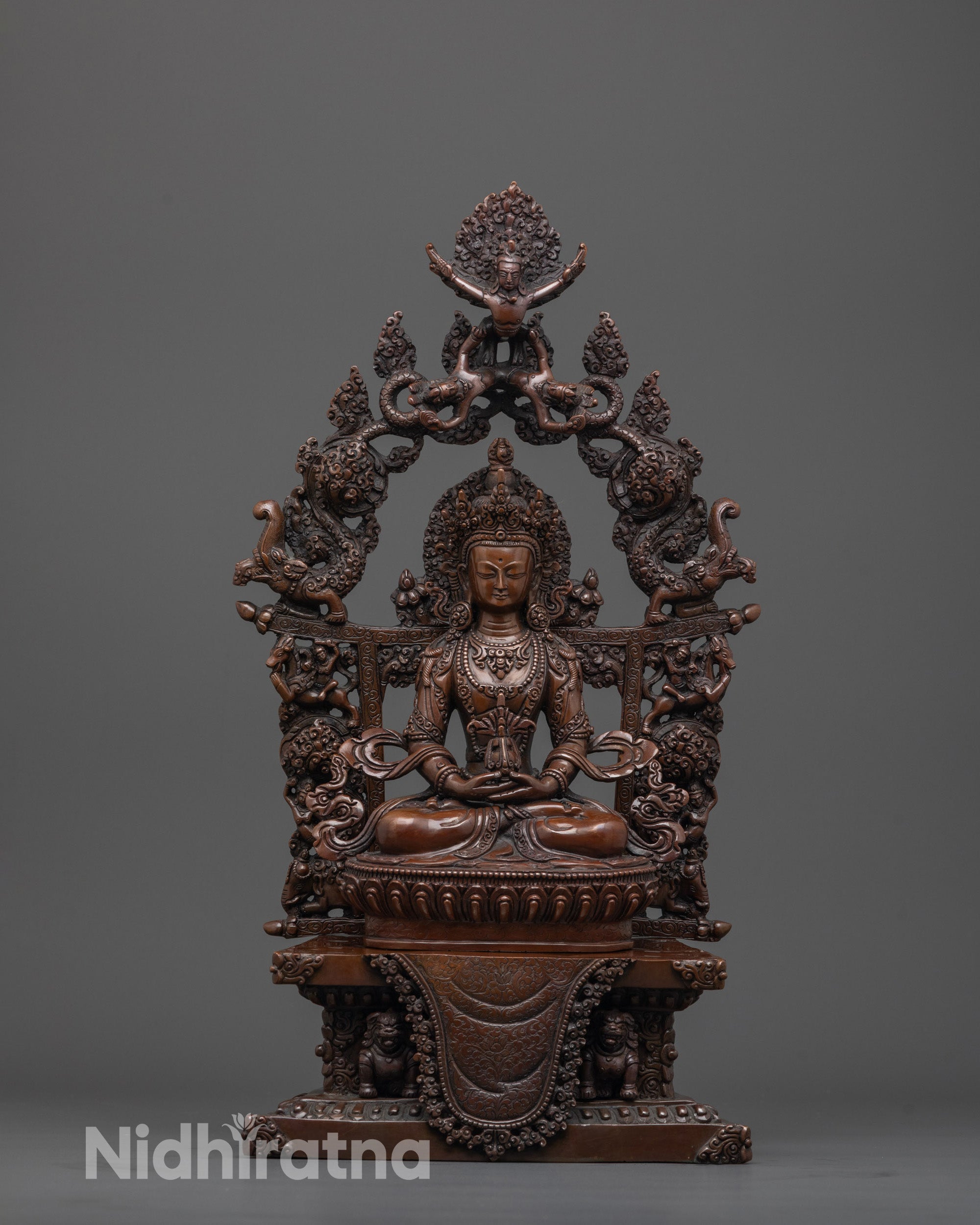 front view of oxidized Amitayus statue seated on lion throne with halo and nectar vase