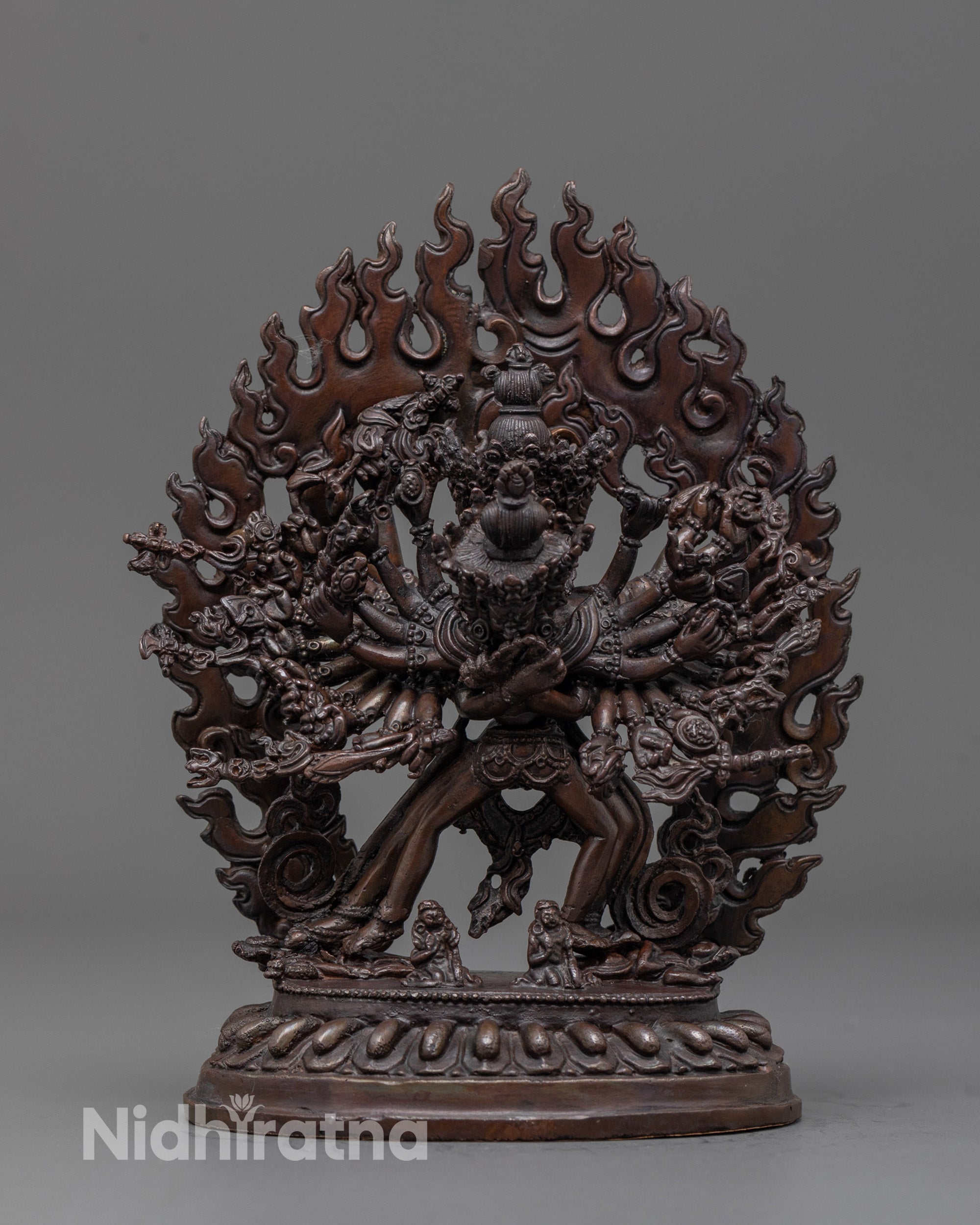 front view of oxidized Kalachakra statue with fiery halo and multiple arms detailed close up