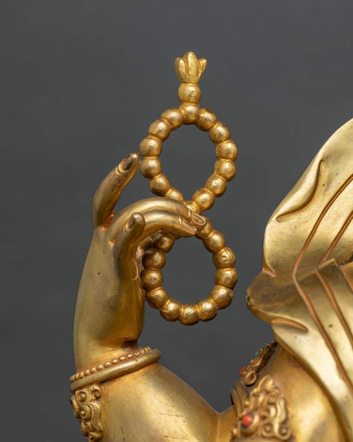 Ganesh raised hand holding a gold rosary for spiritual discipline on a handcrafted Nepali statue
